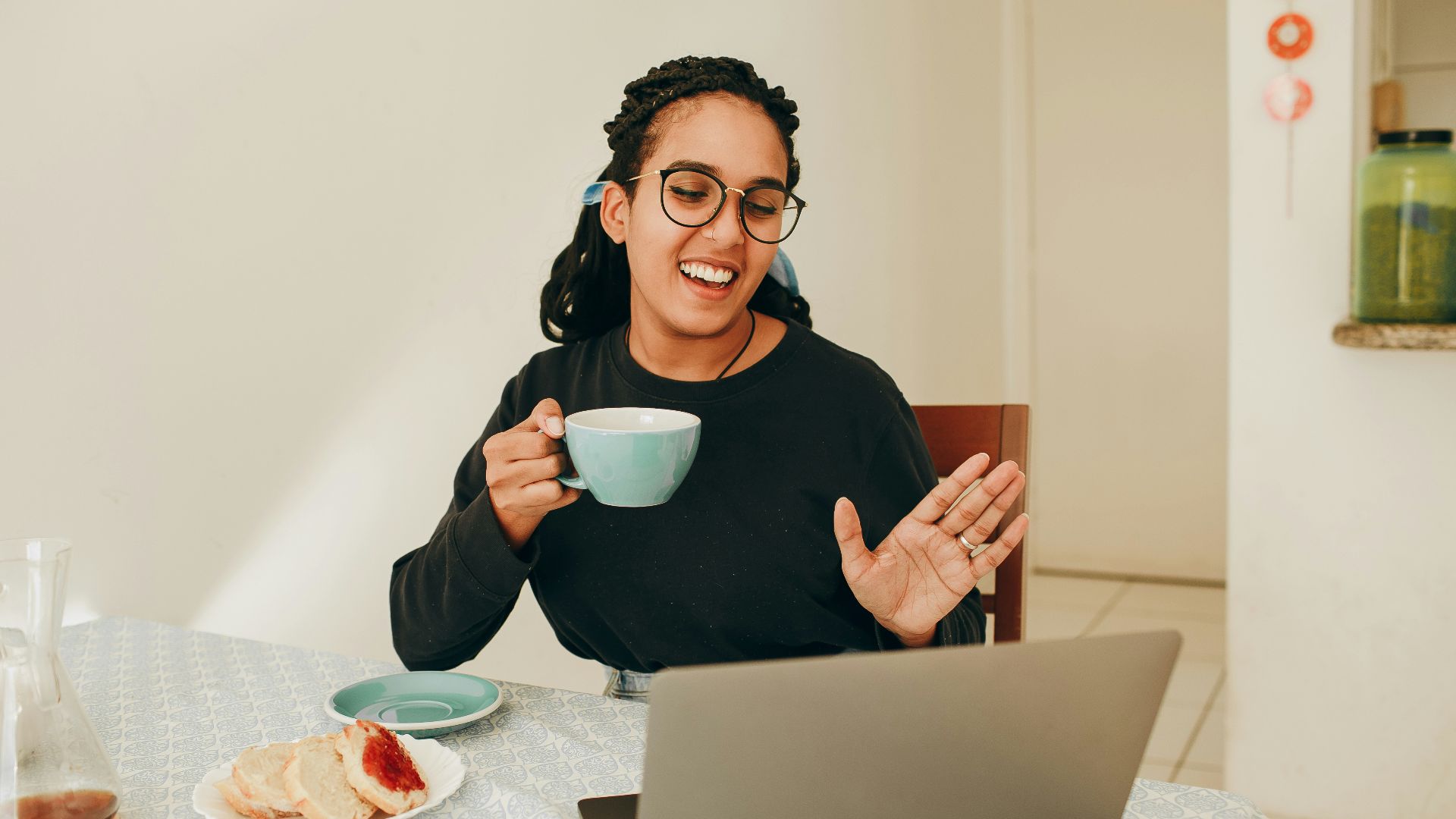 woman in black long sleeve shirt holding white ceramic mug