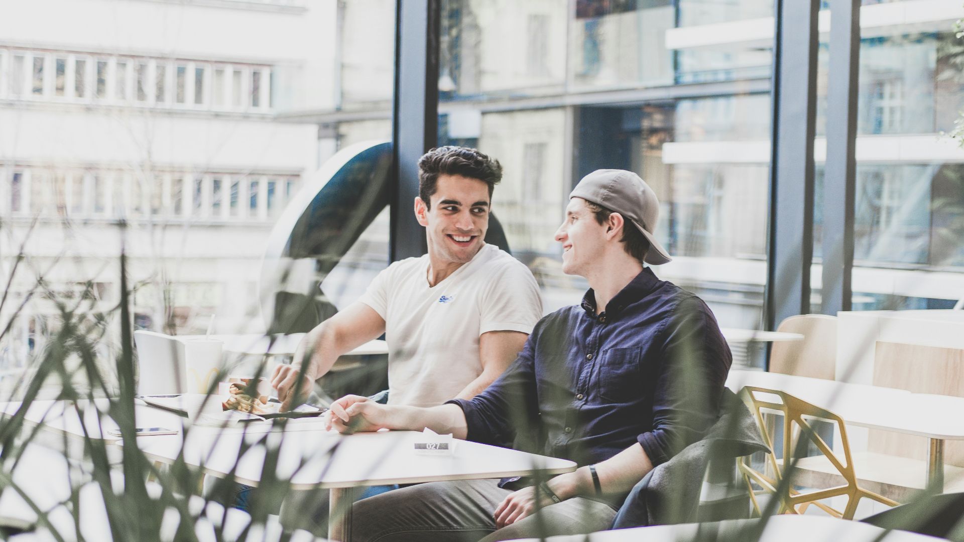 two men sitting on chair in front of table