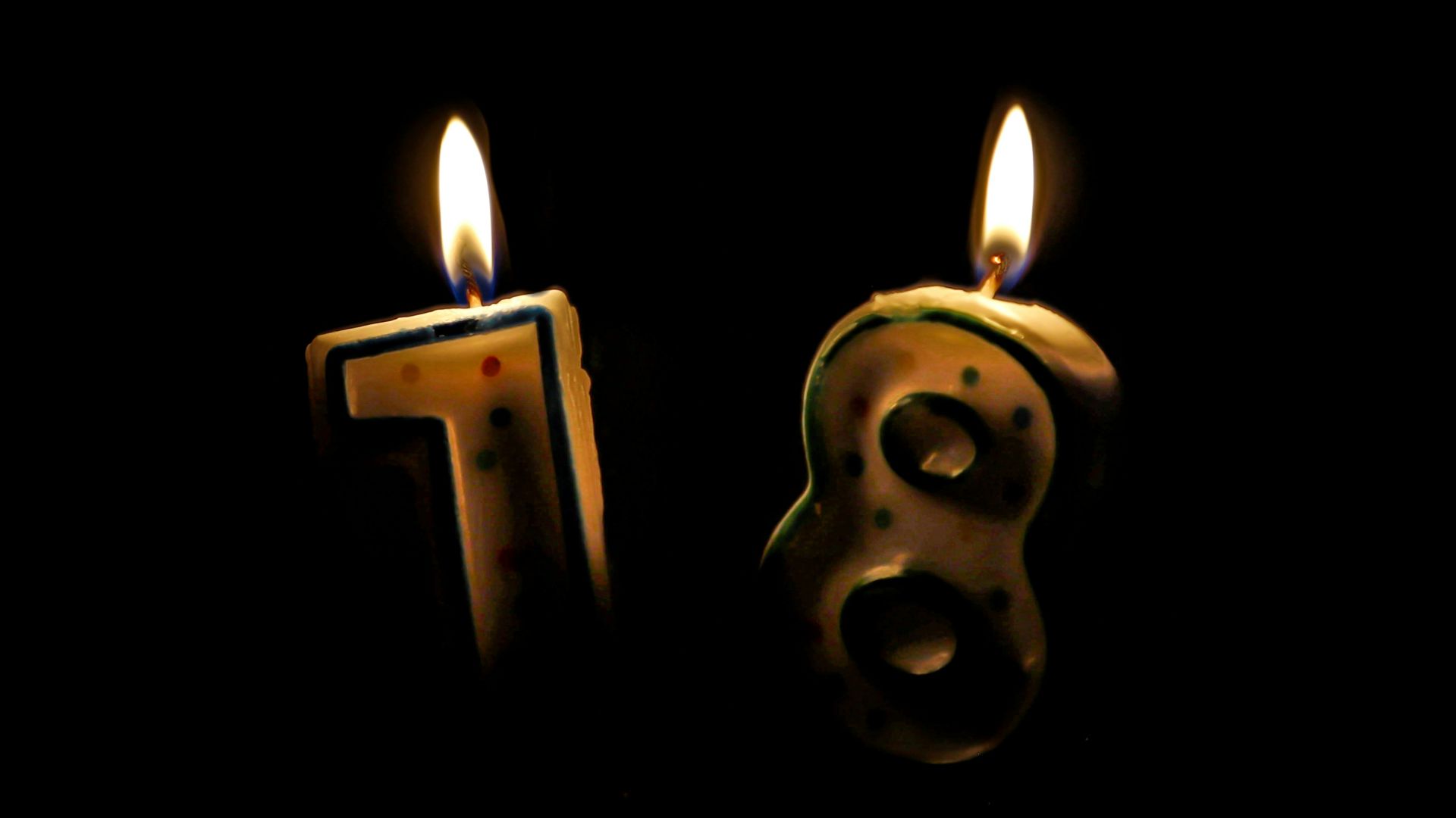 two candles are lit in the shape of numbers