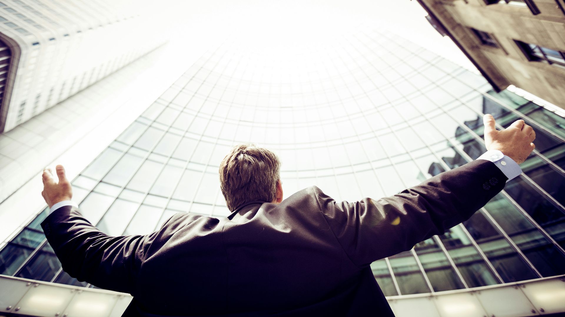 low-angle photography of man in the middle of buidligns