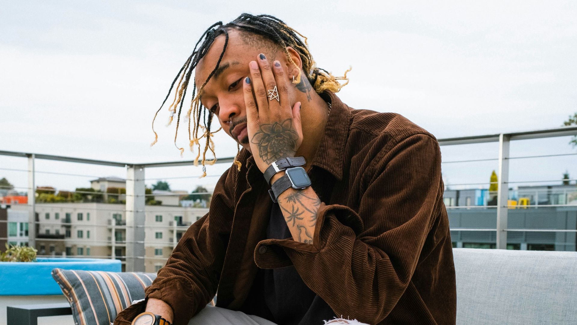 a man with dreadlocks sitting on a bench