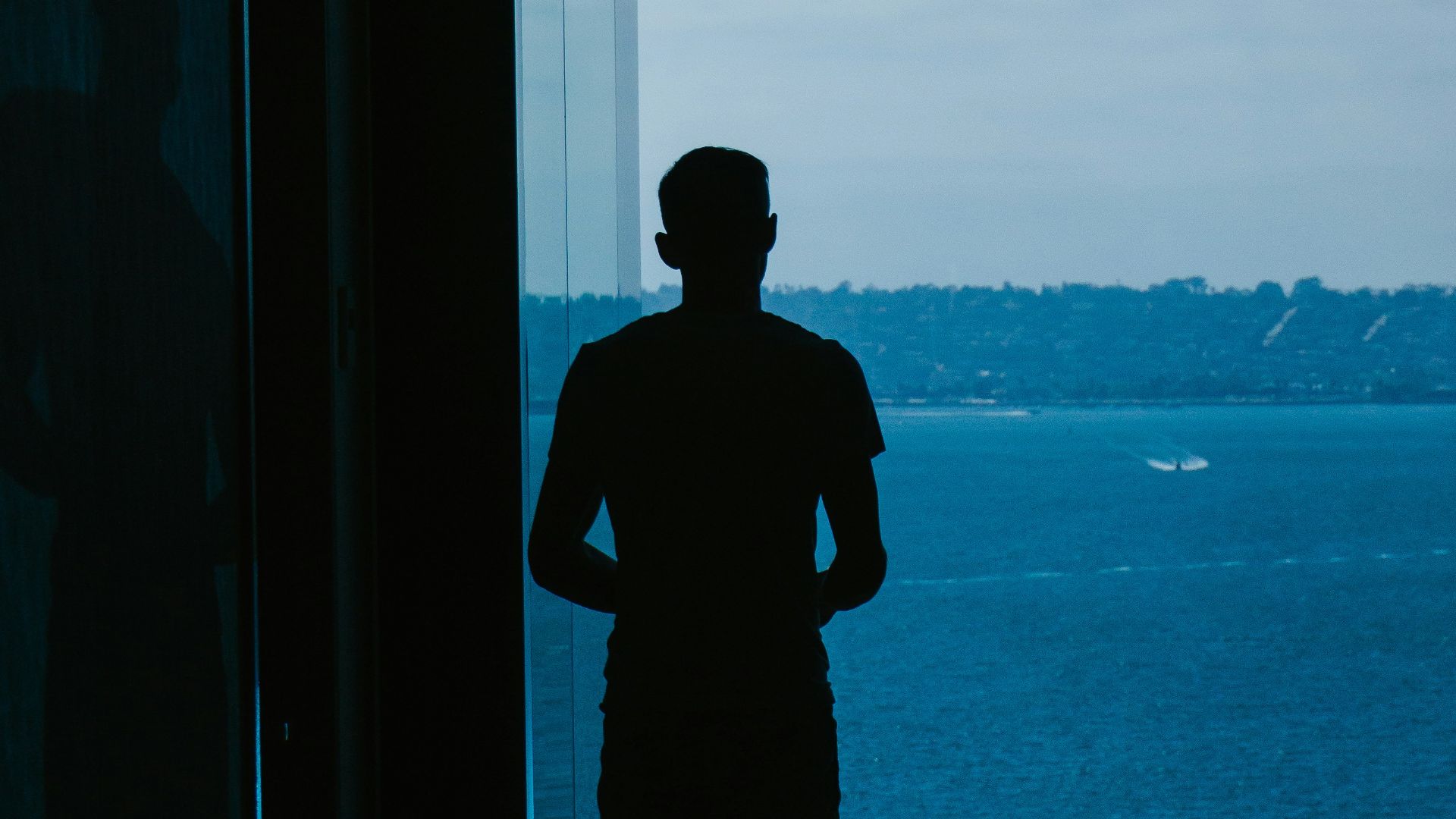 a silhouette of a man standing in a doorway