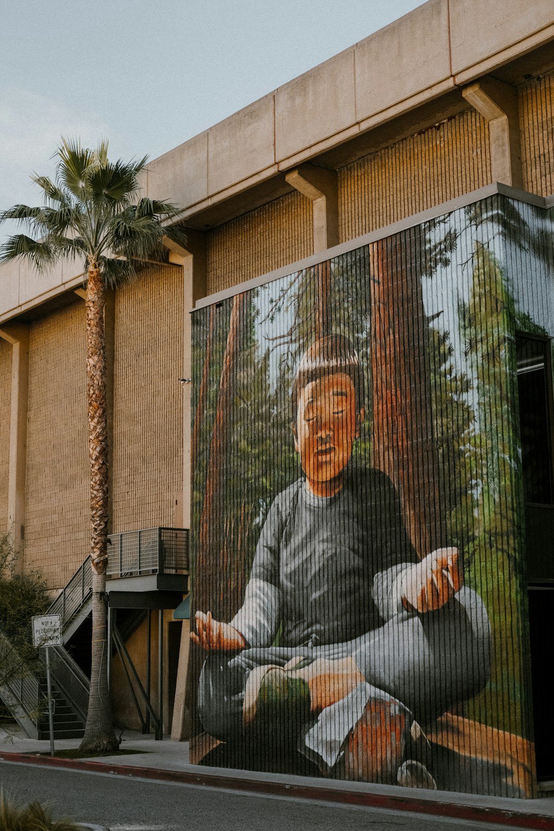 a mural of a man sitting on a bench in front of a building