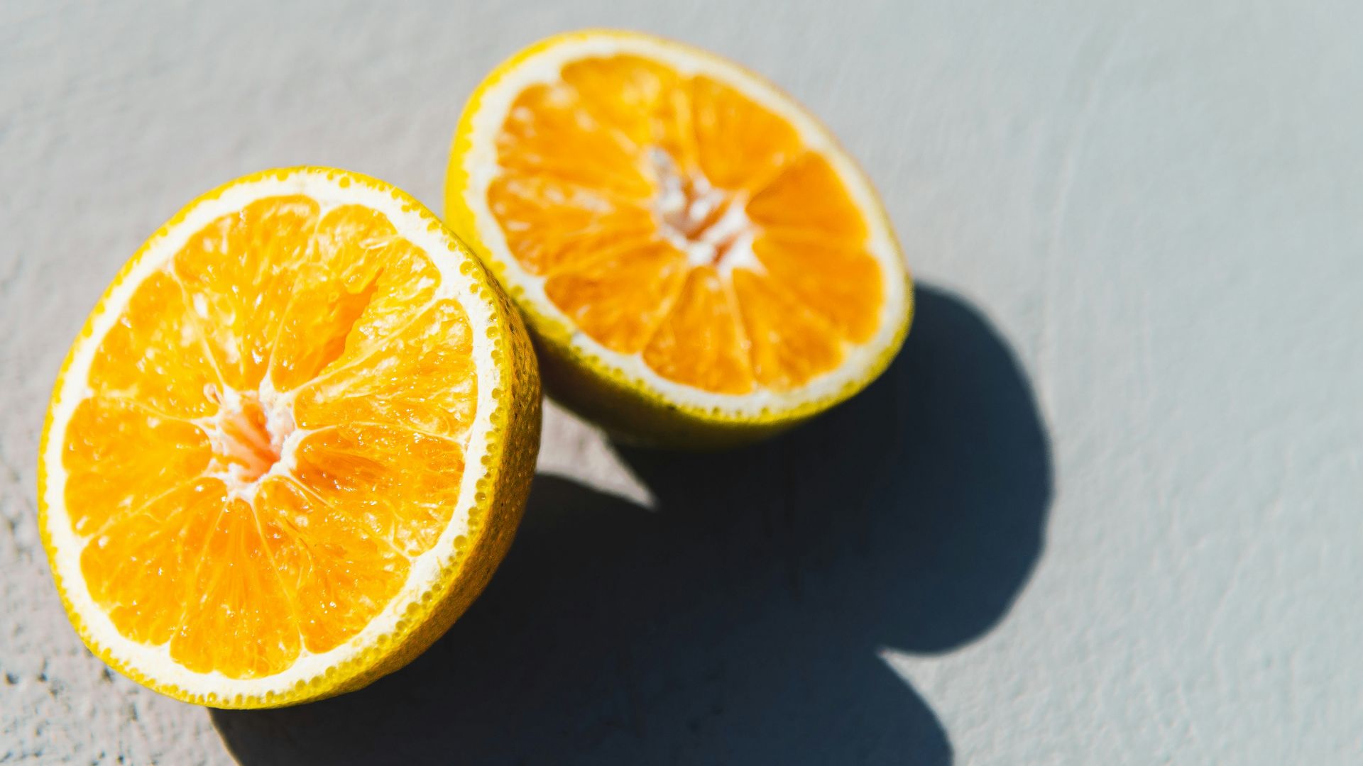 two oranges cut in half sitting on a table