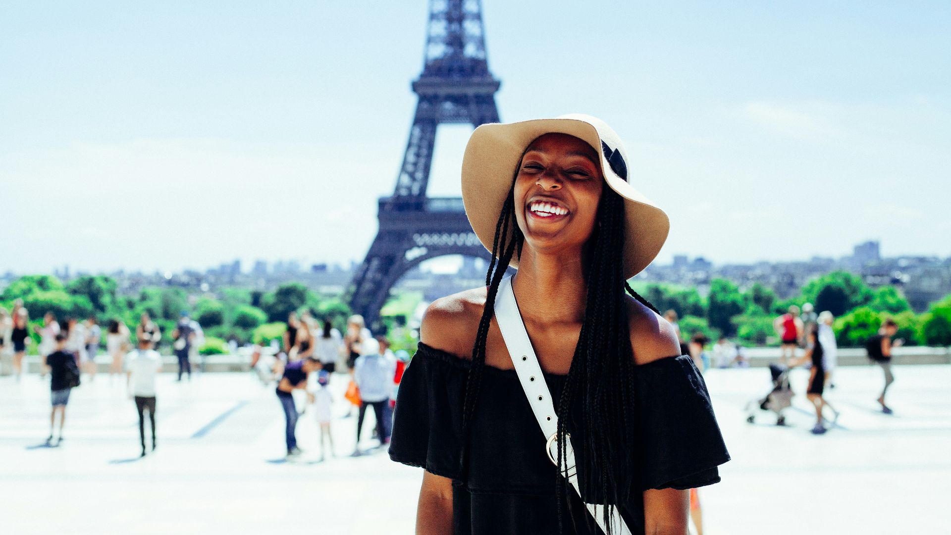 woman standing behind Eiffel Tower during daytime