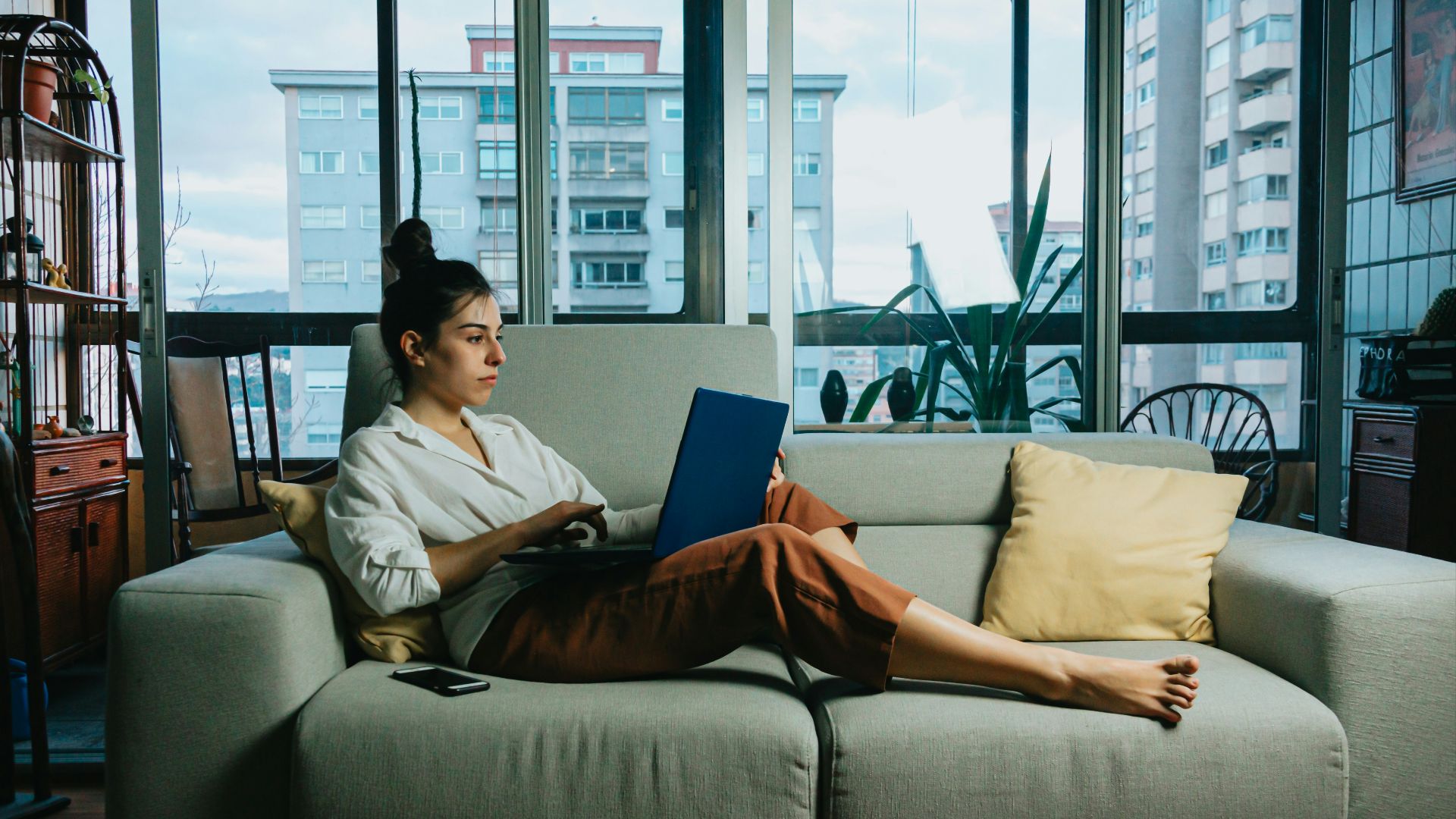 woman in white long sleeve shirt sitting on white couch
