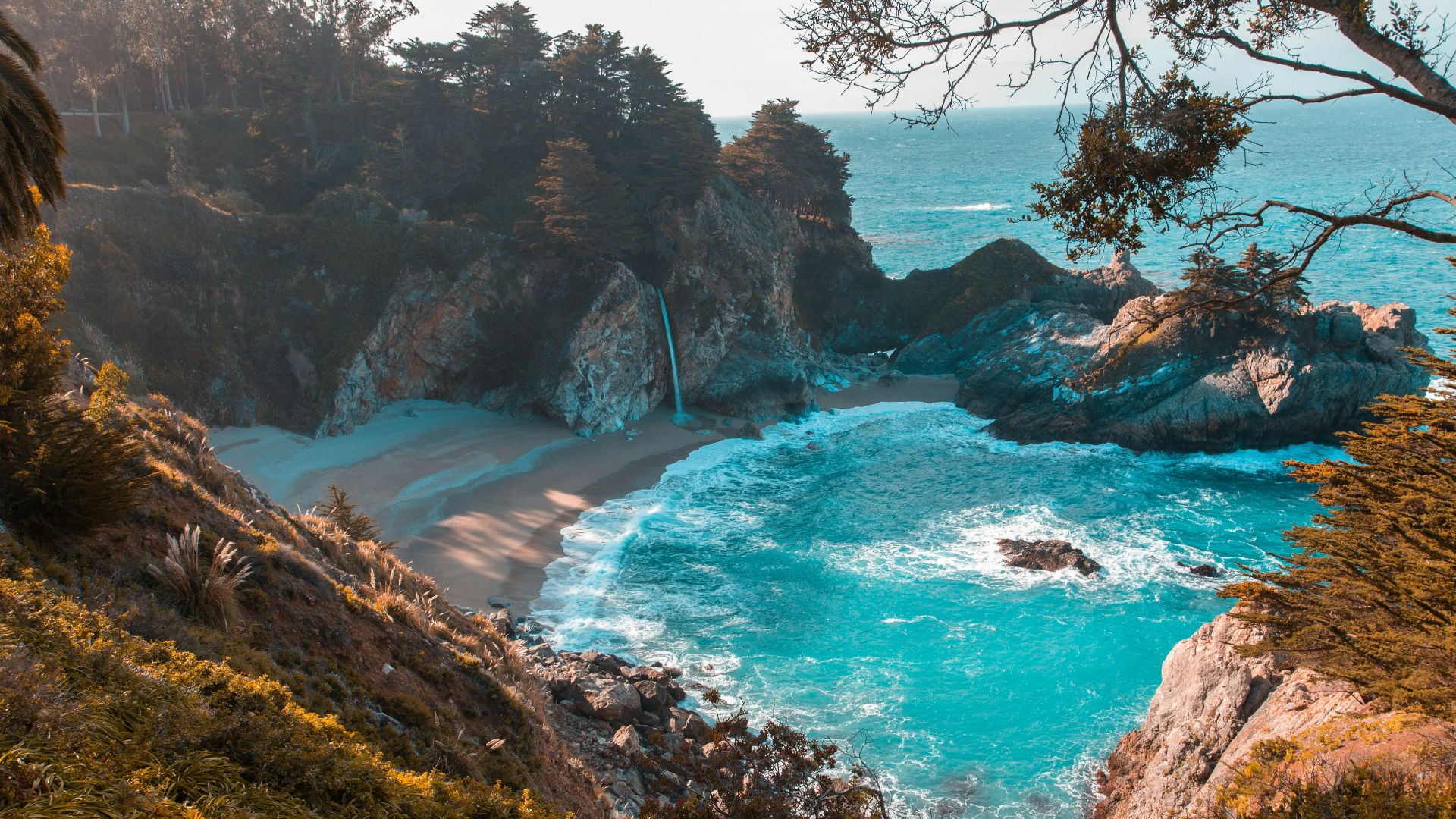 body of water near trees and mountain cliff during daytime