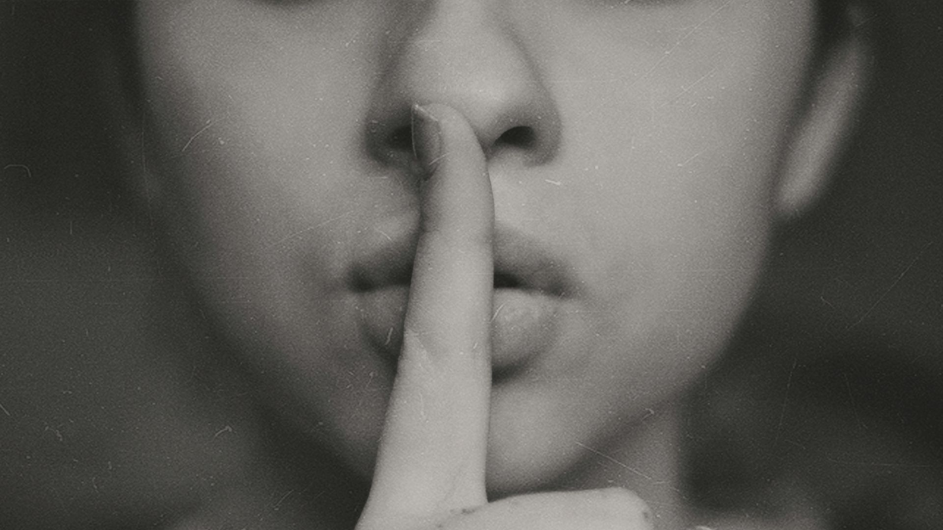 grayscale photo of woman doing silent hand sign