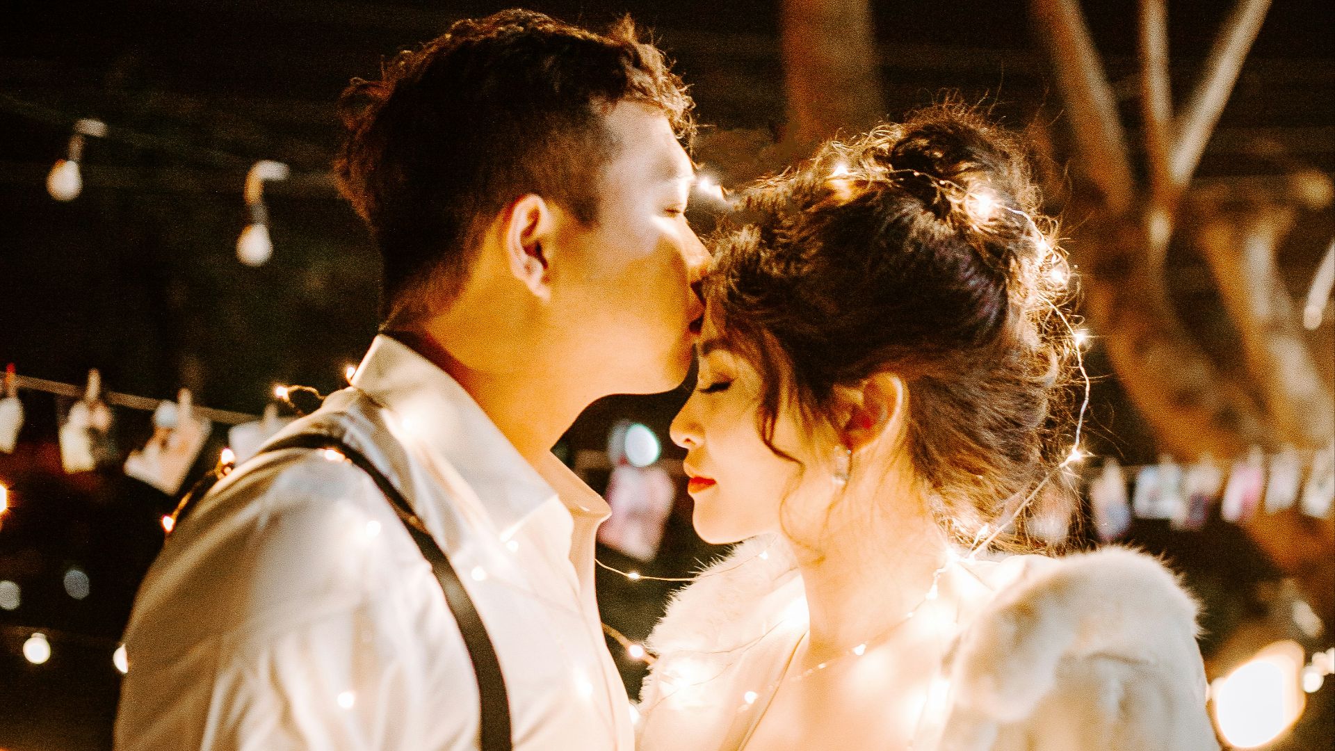 man kissing woman's forehead