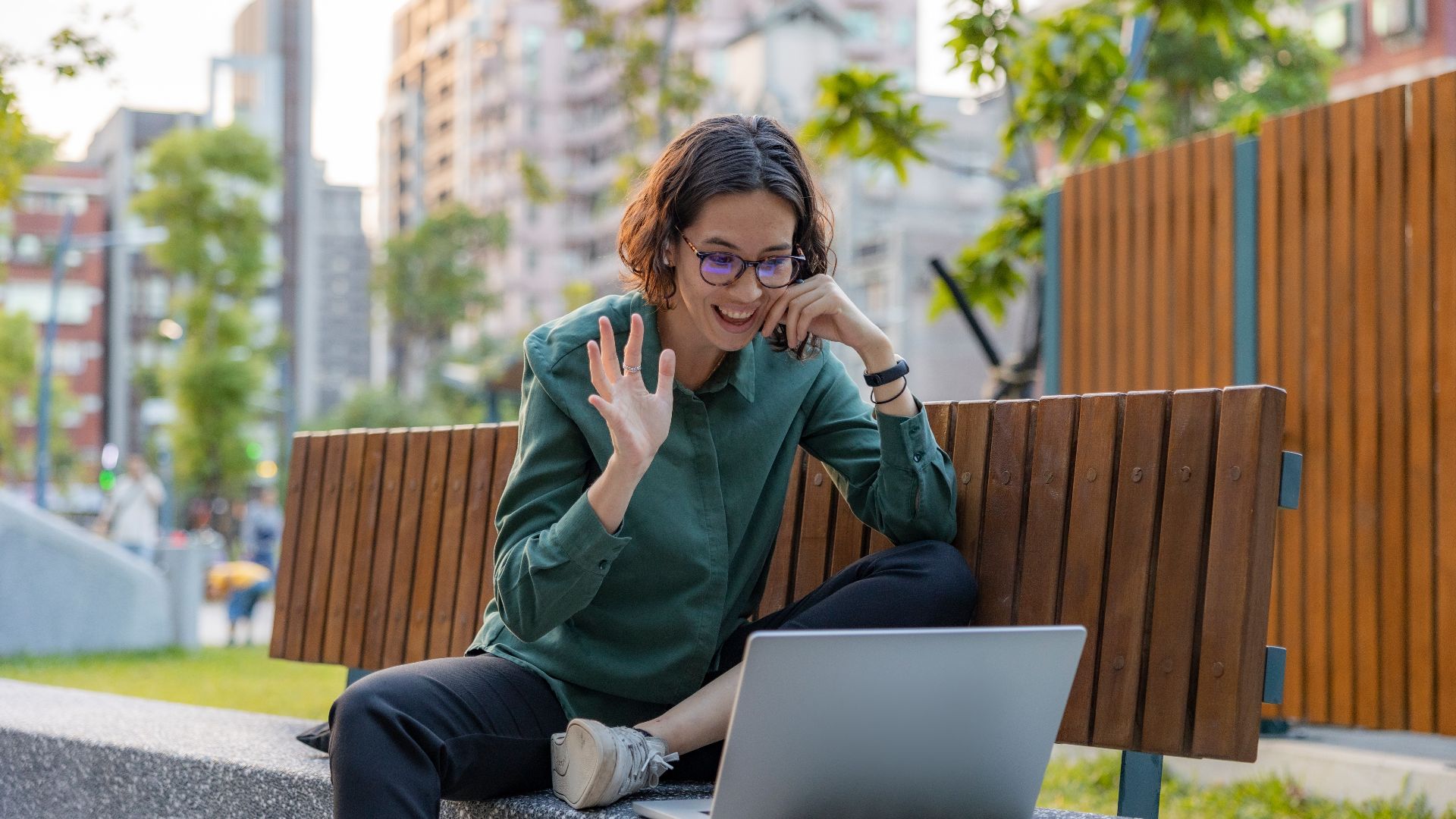 a woman sitting on a bench with a laptop
