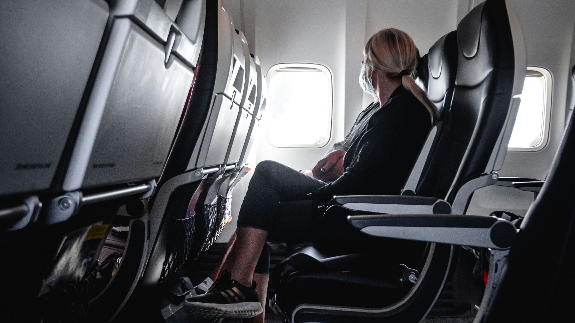 a woman sitting in a seat on an airplane