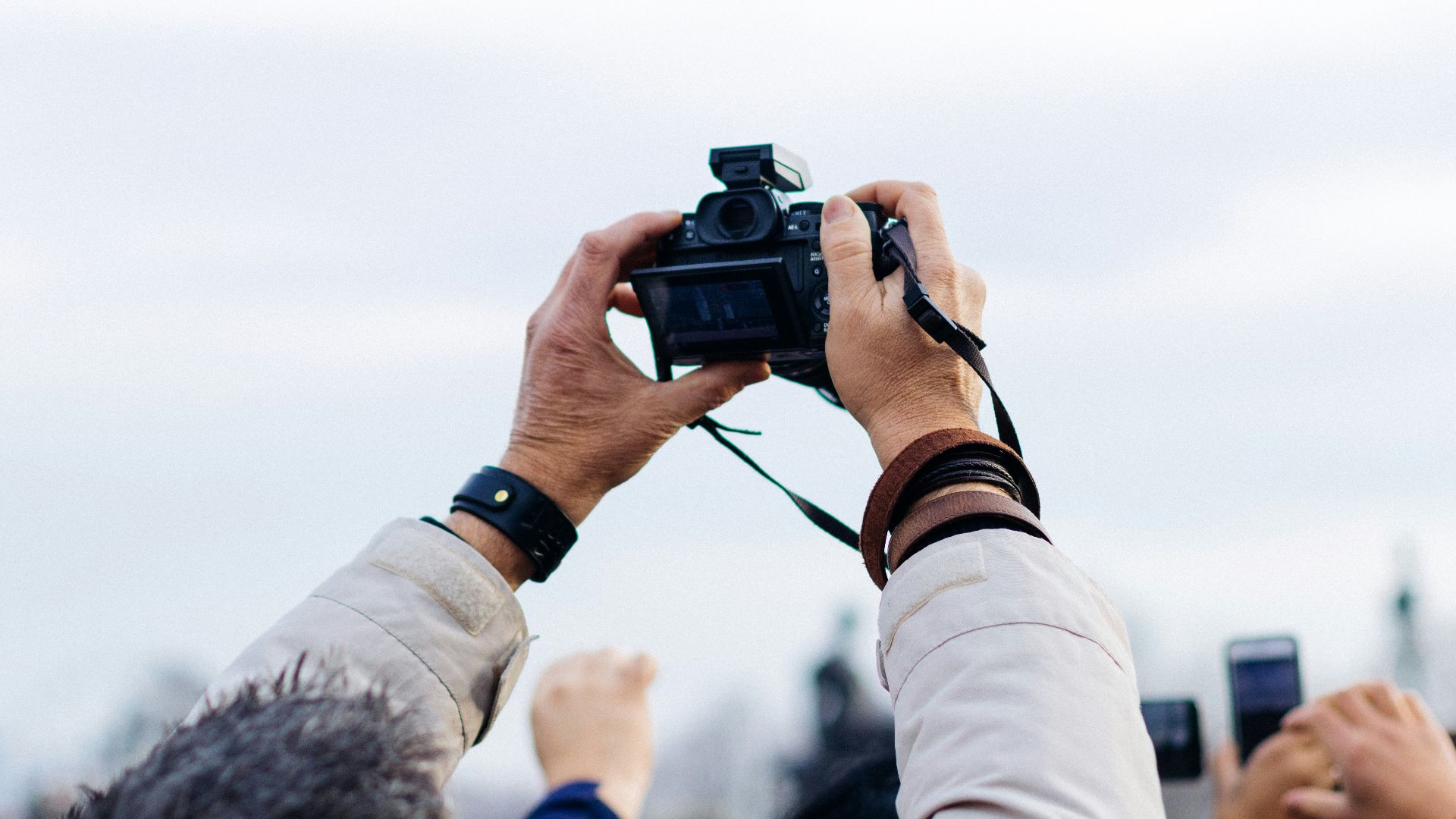 person holding black DSLR camera taking picture during daytime