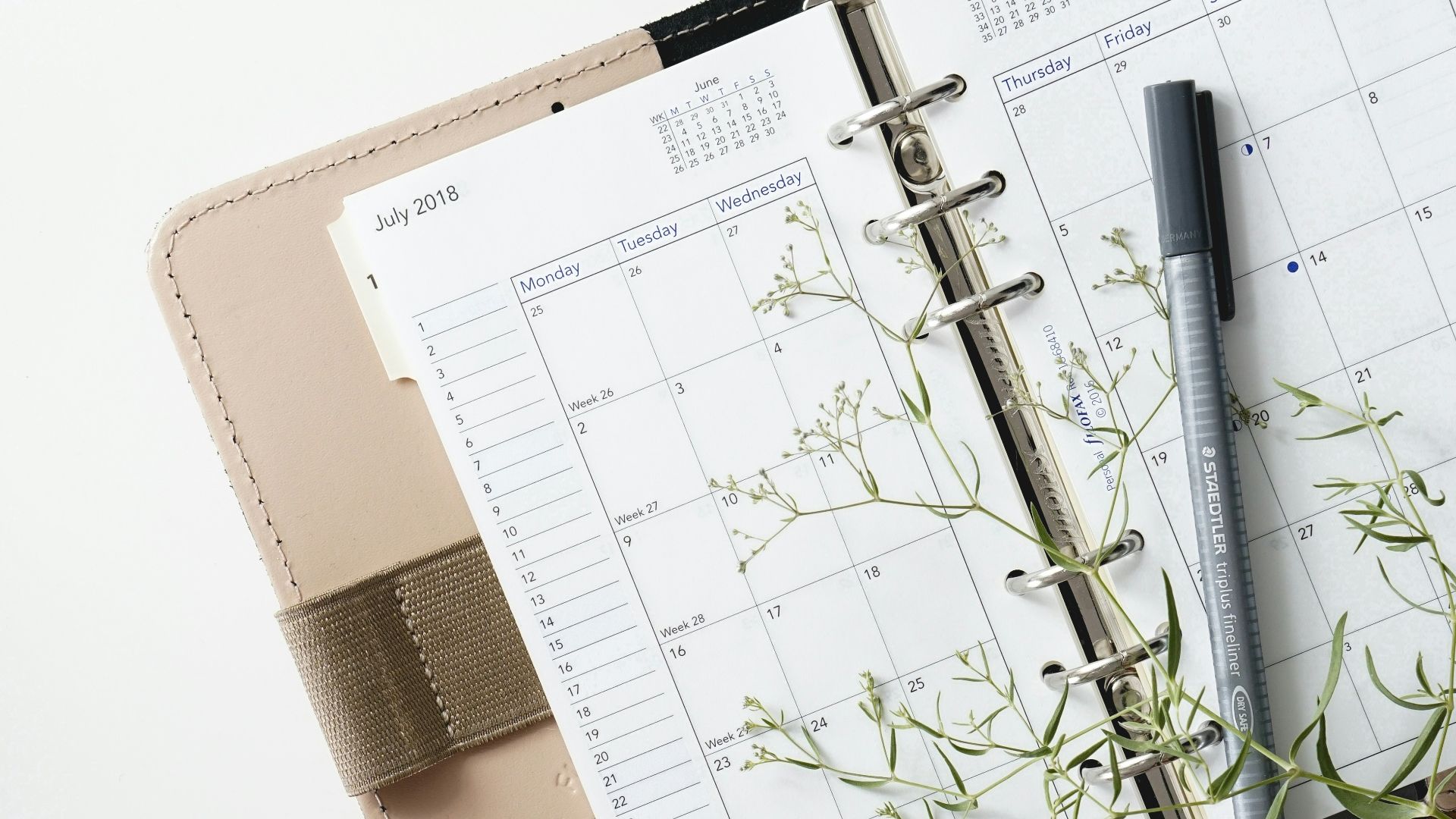 grey and black pen on calendar book