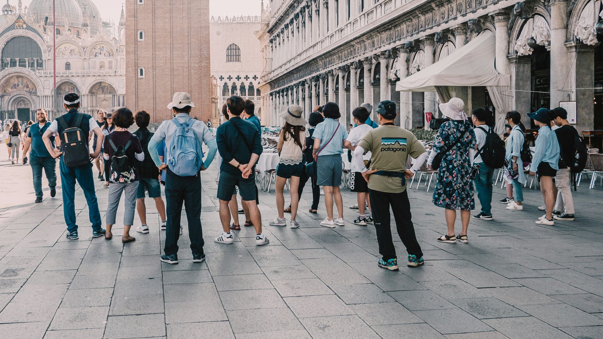 a group of people standing on a street next to a tall building