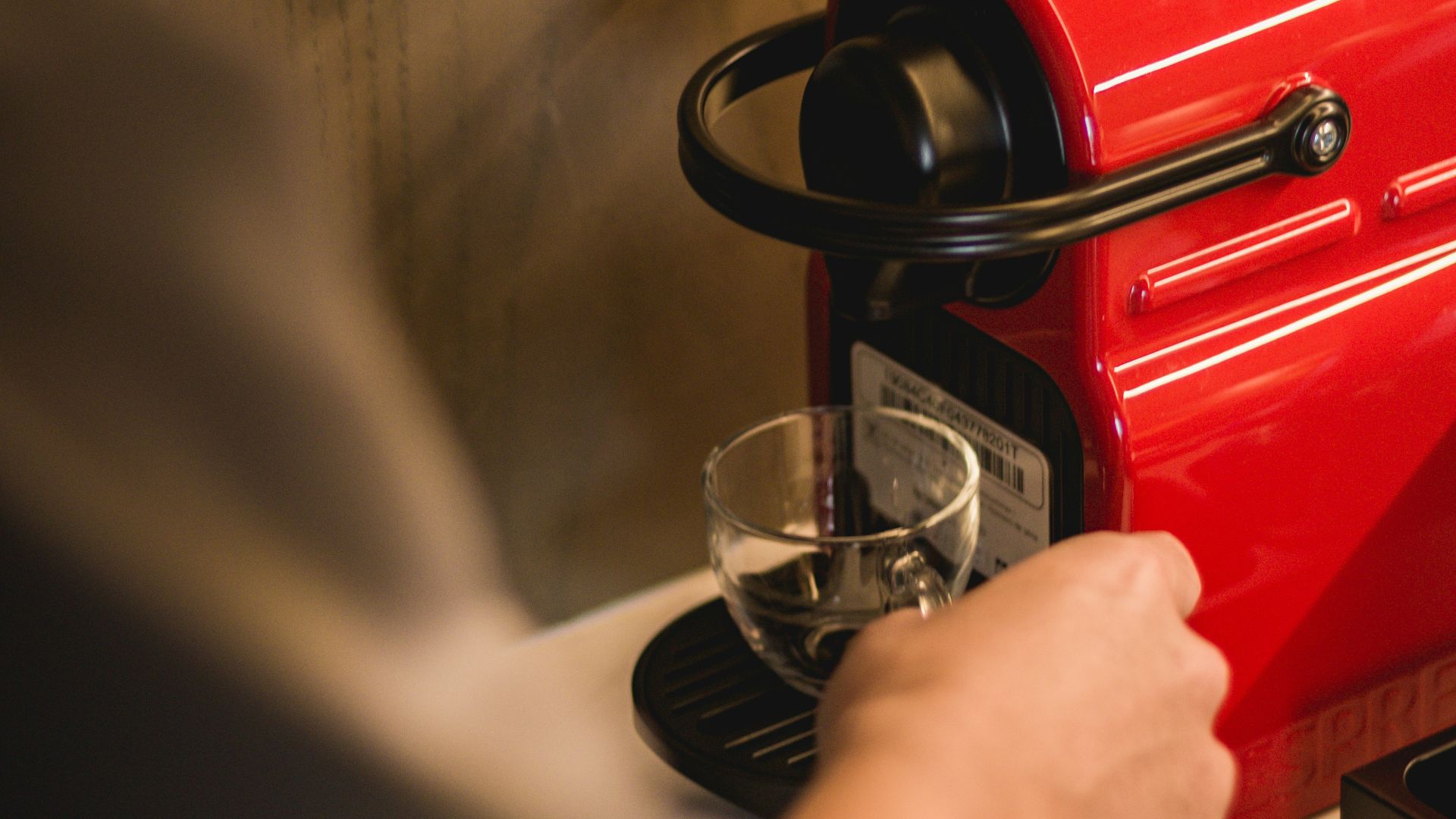 person holding red coffee maker