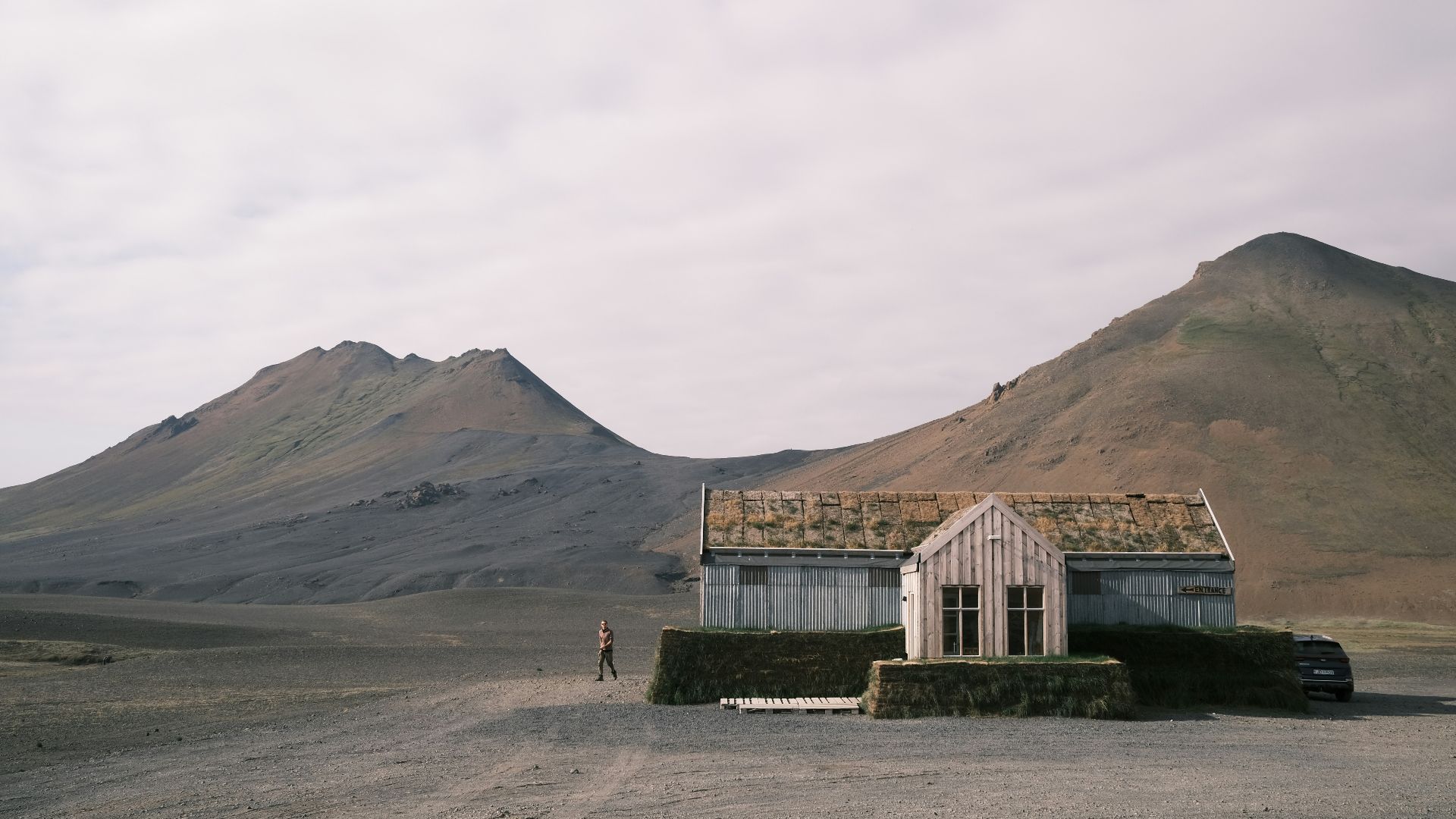 a couple of houses sitting on top of a dirt field