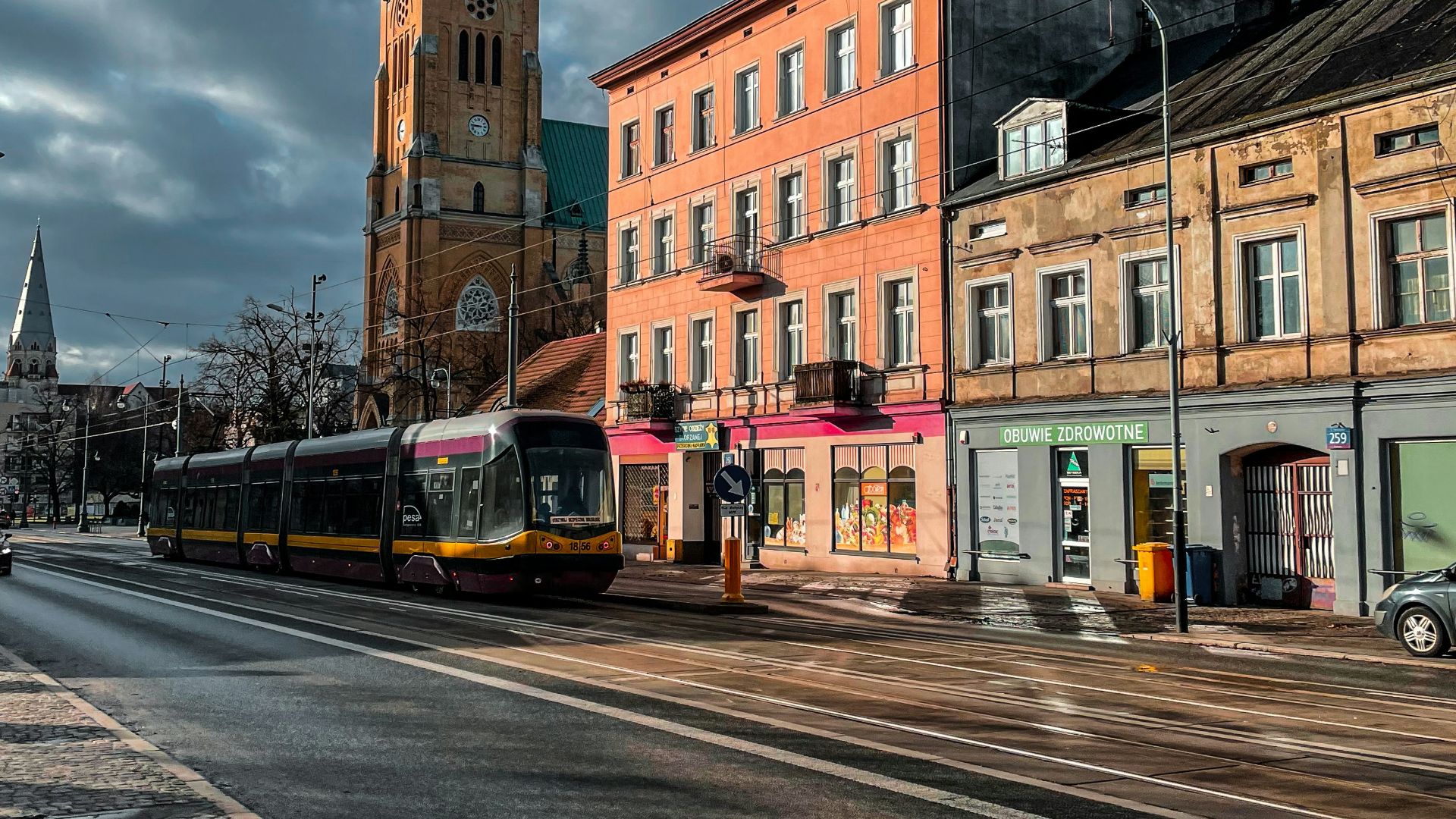 a city street with buildings and a train on the tracks