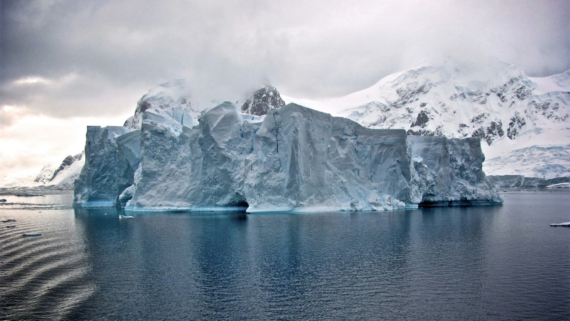 white iceberg near white mountains