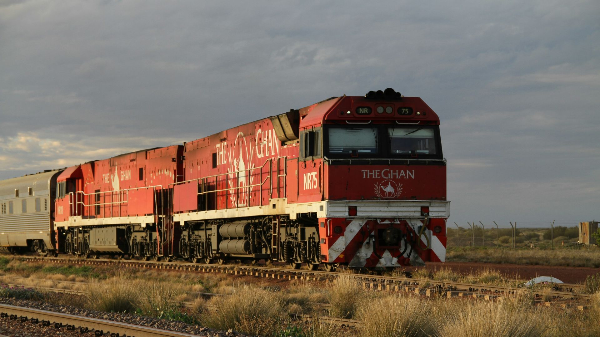 a red and white train traveling down train tracks