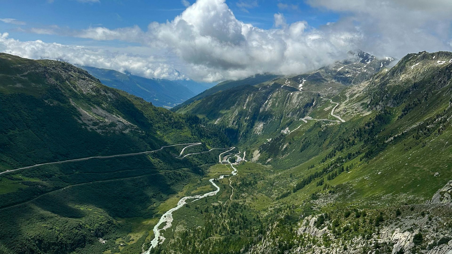 a scenic view of a winding road in the mountains