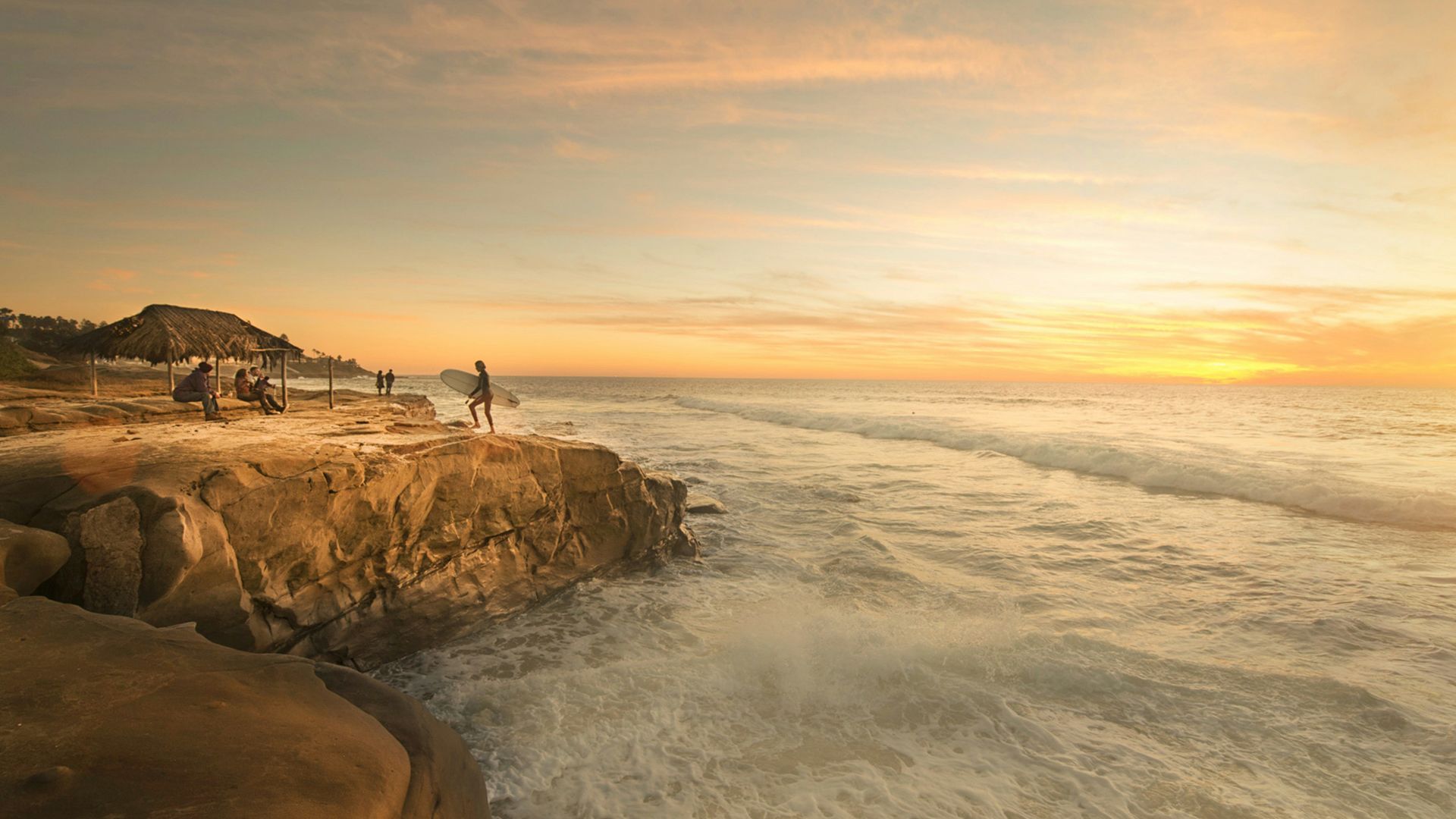 person holding surfboard near body of water
