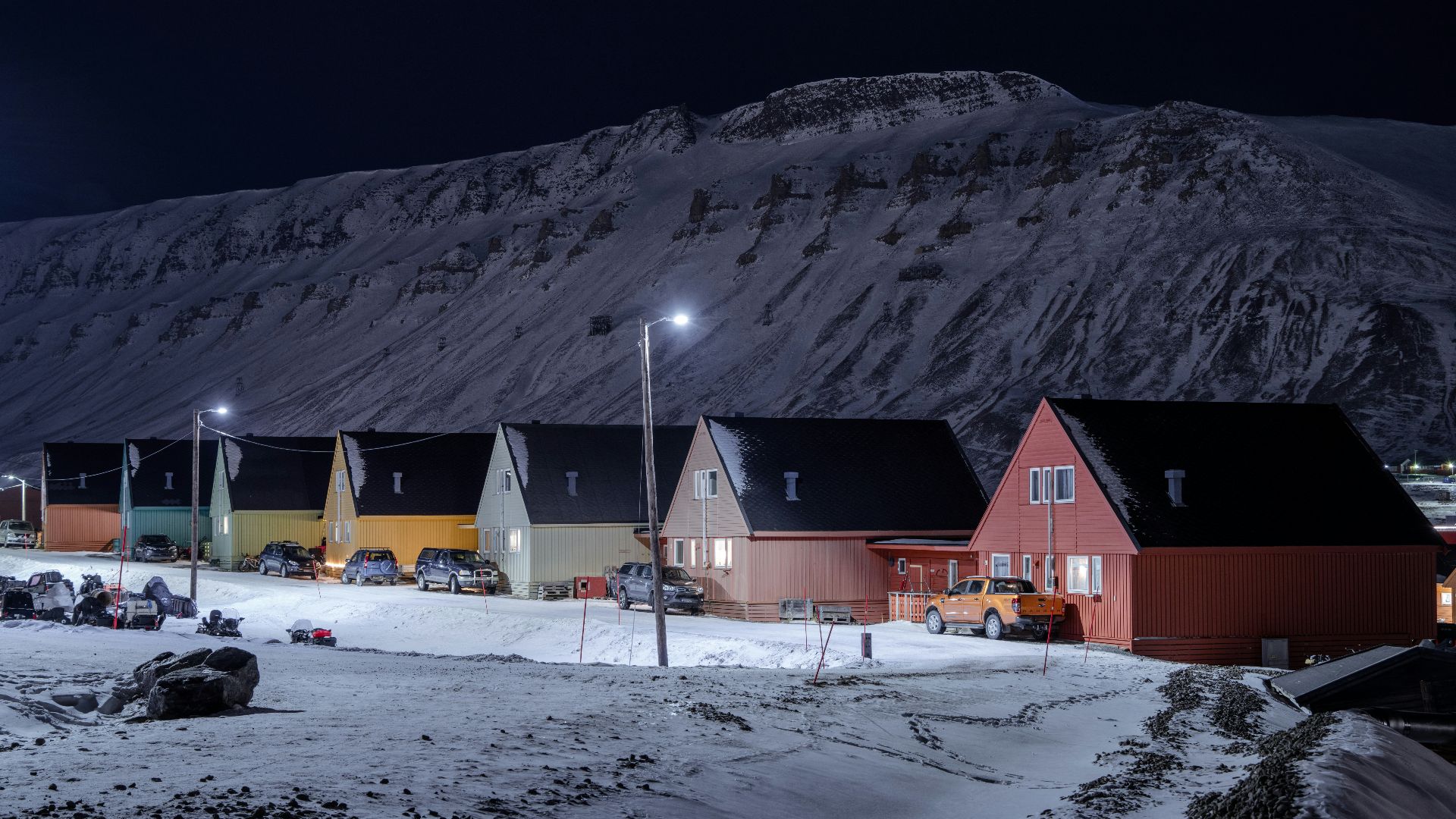 a group of houses sitting on top of a snow covered hillside