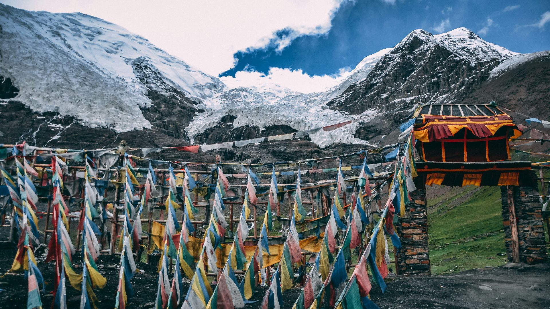multicolored streamers near snow mountain under blue and white cloudy sky