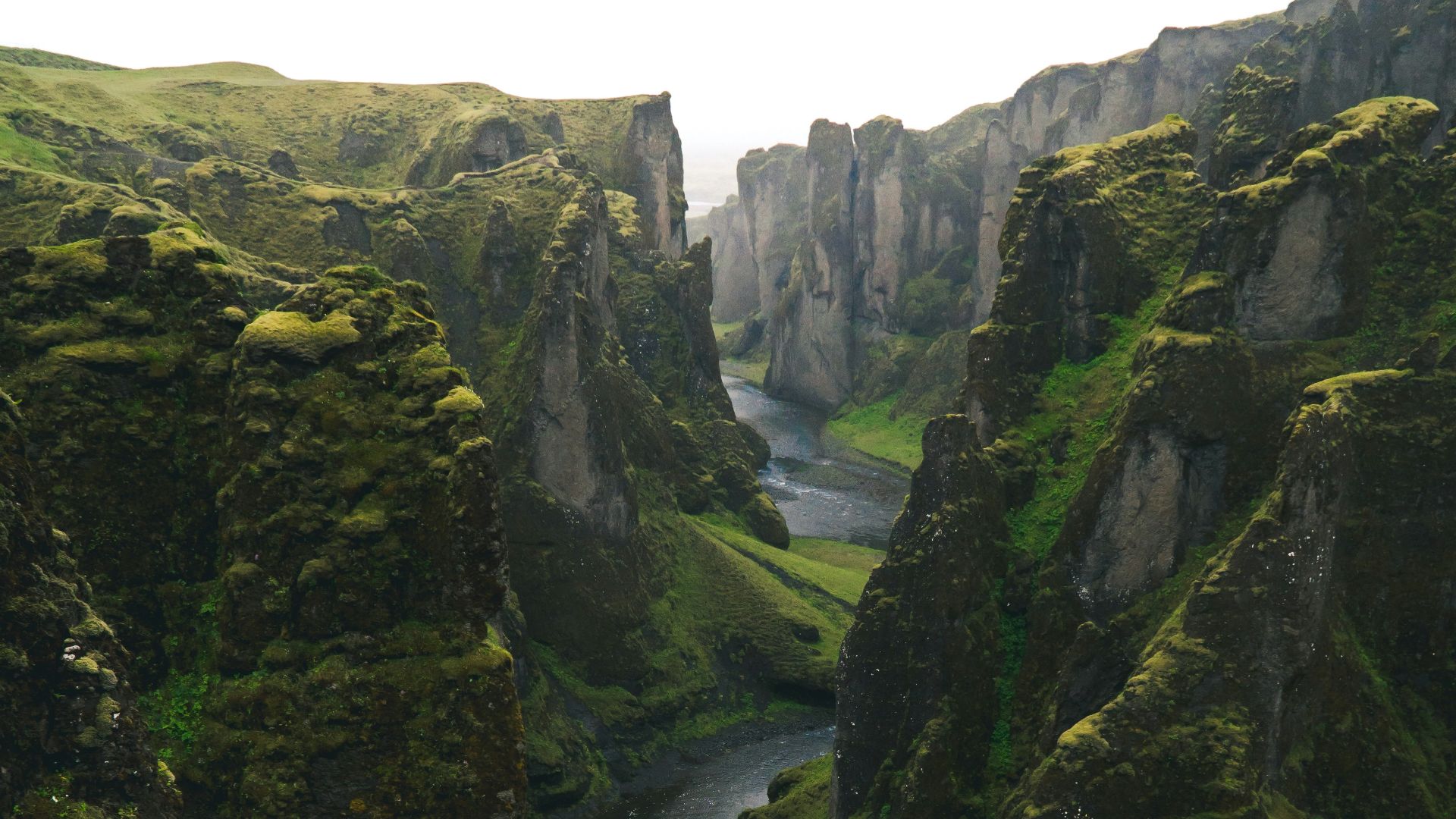aerial view photography of body of water across green mountains