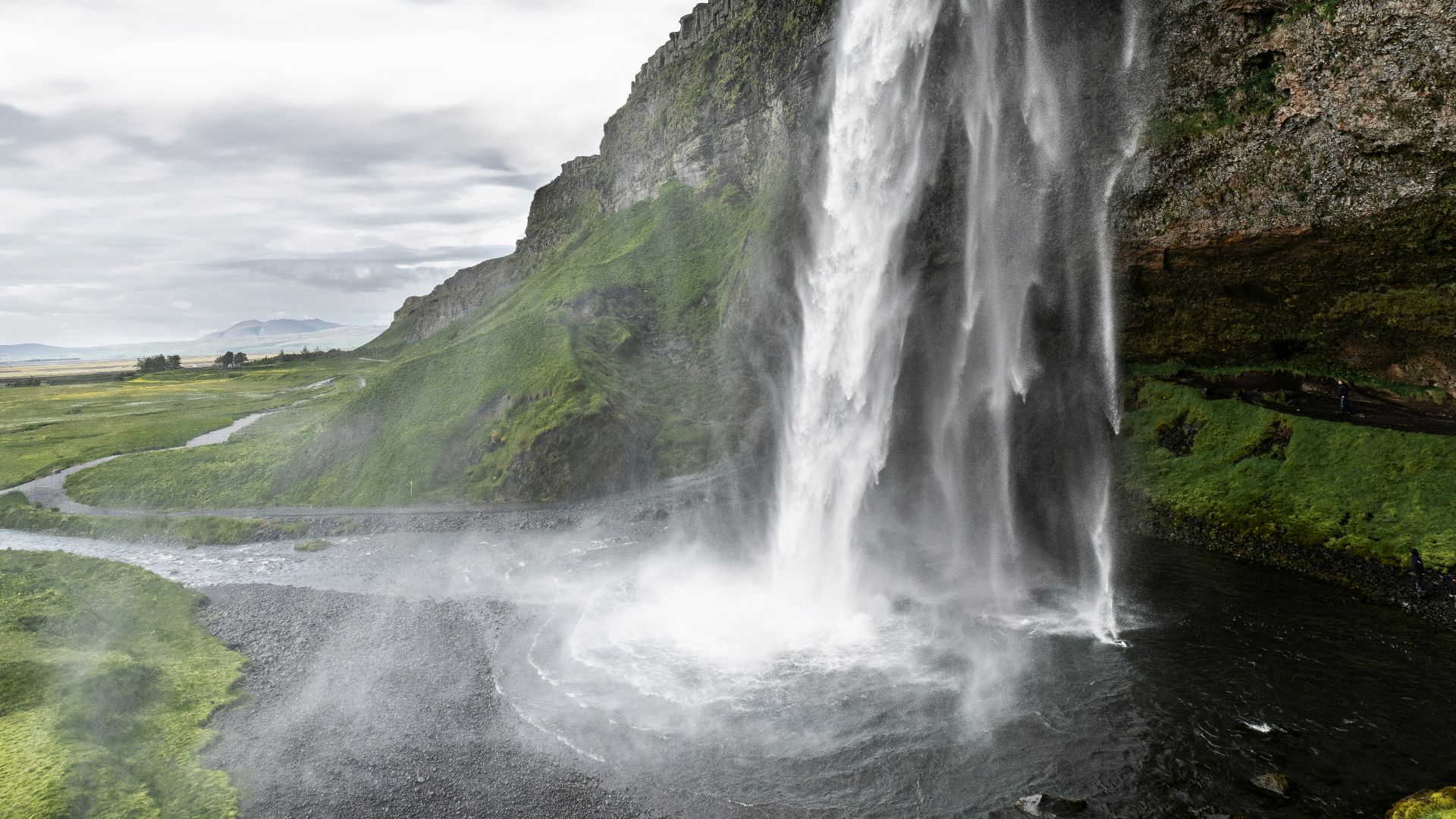 A large waterfall is in the middle of a field