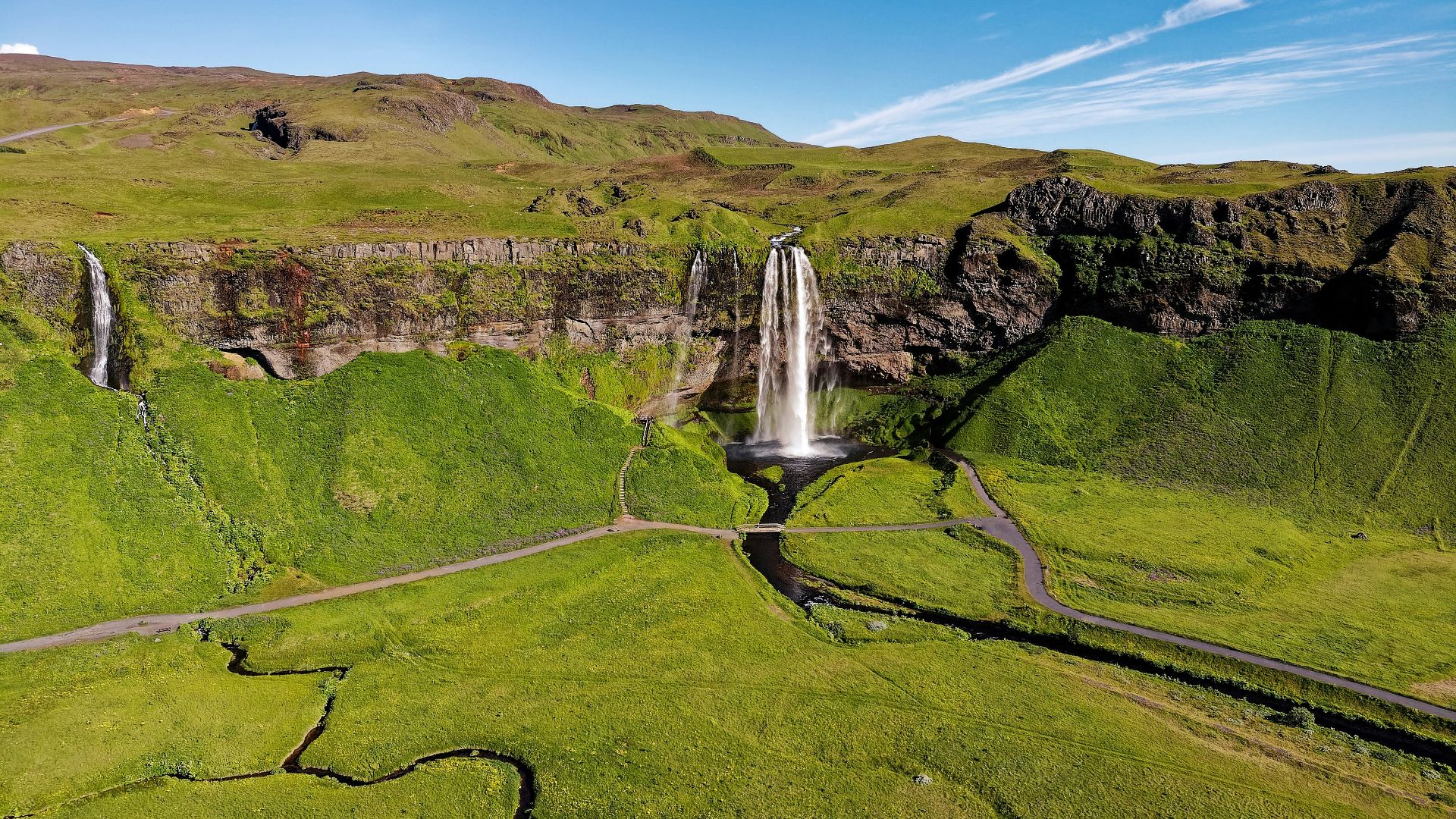 waterfalls on green grass field during daytime