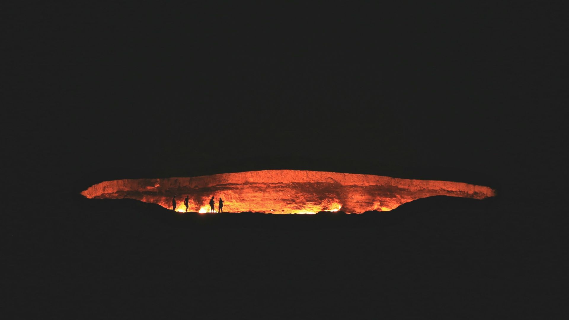 photography of people near cave at night time