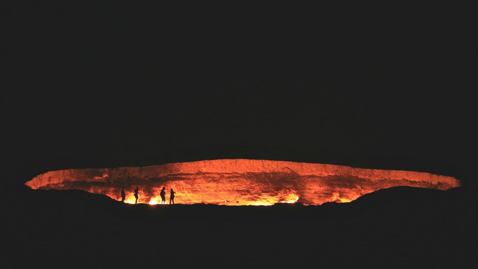 photography of people near cave at night time