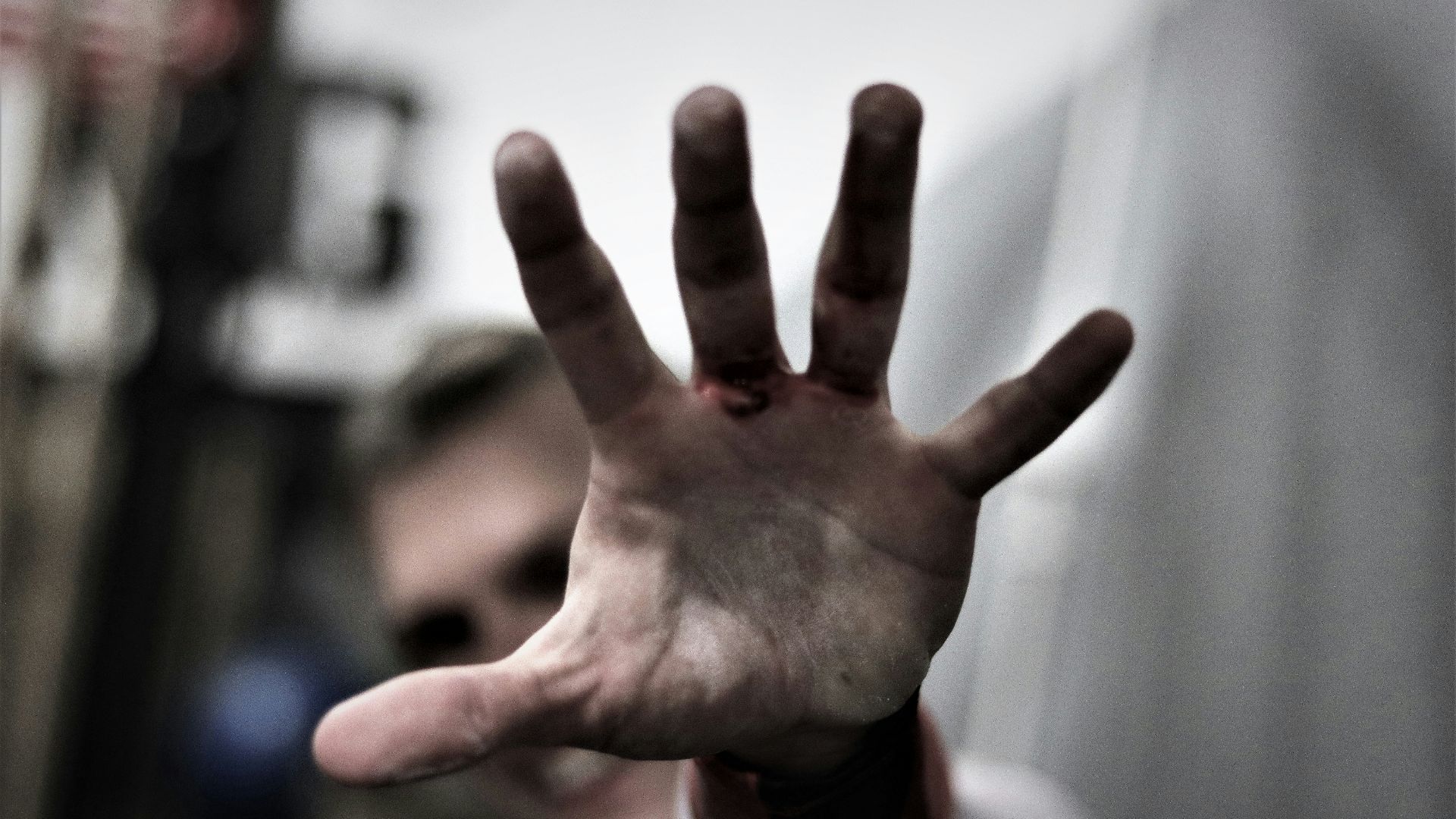 persons left hand in tilt shift lens