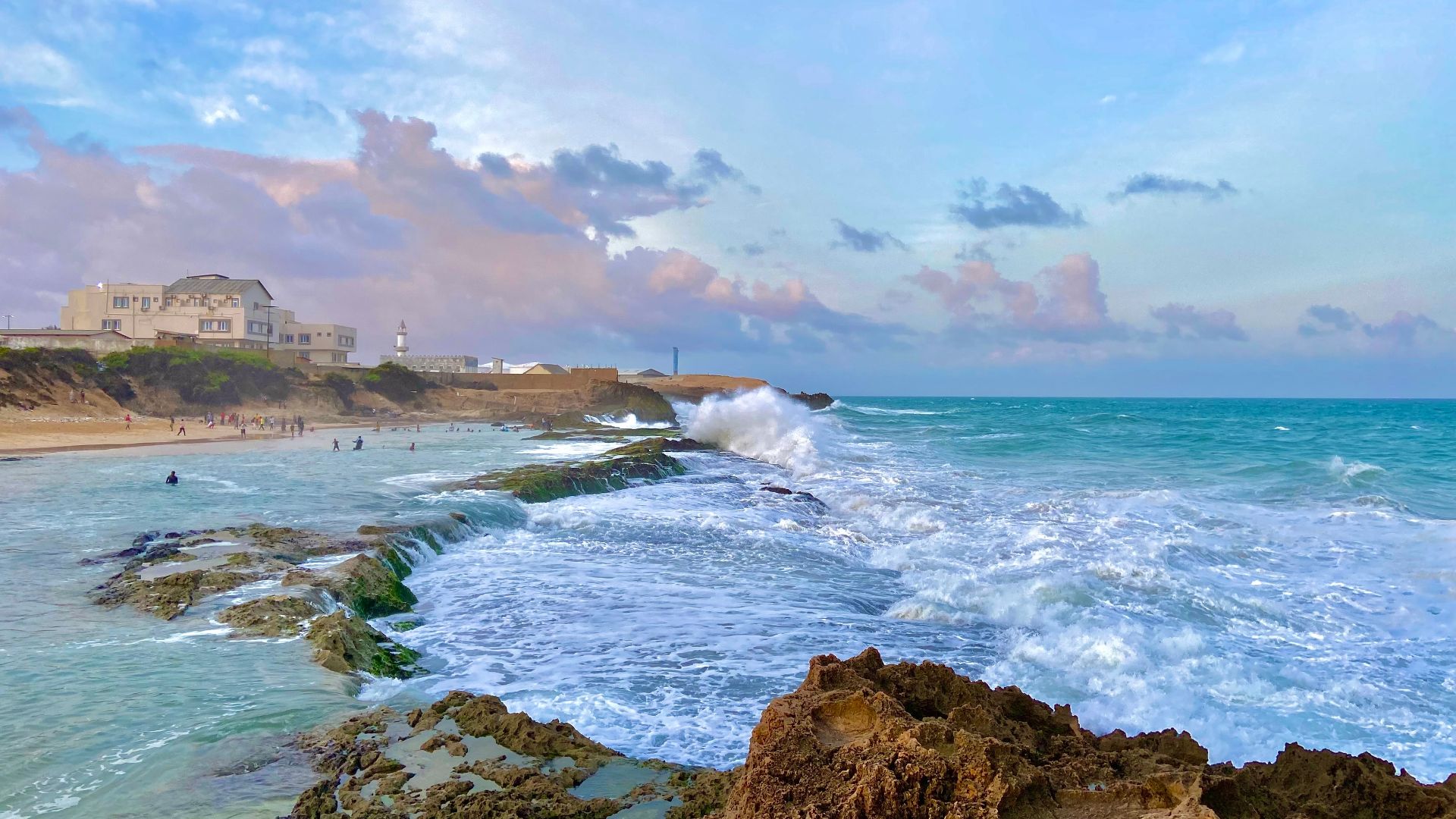 a rocky beach with a building in the background
