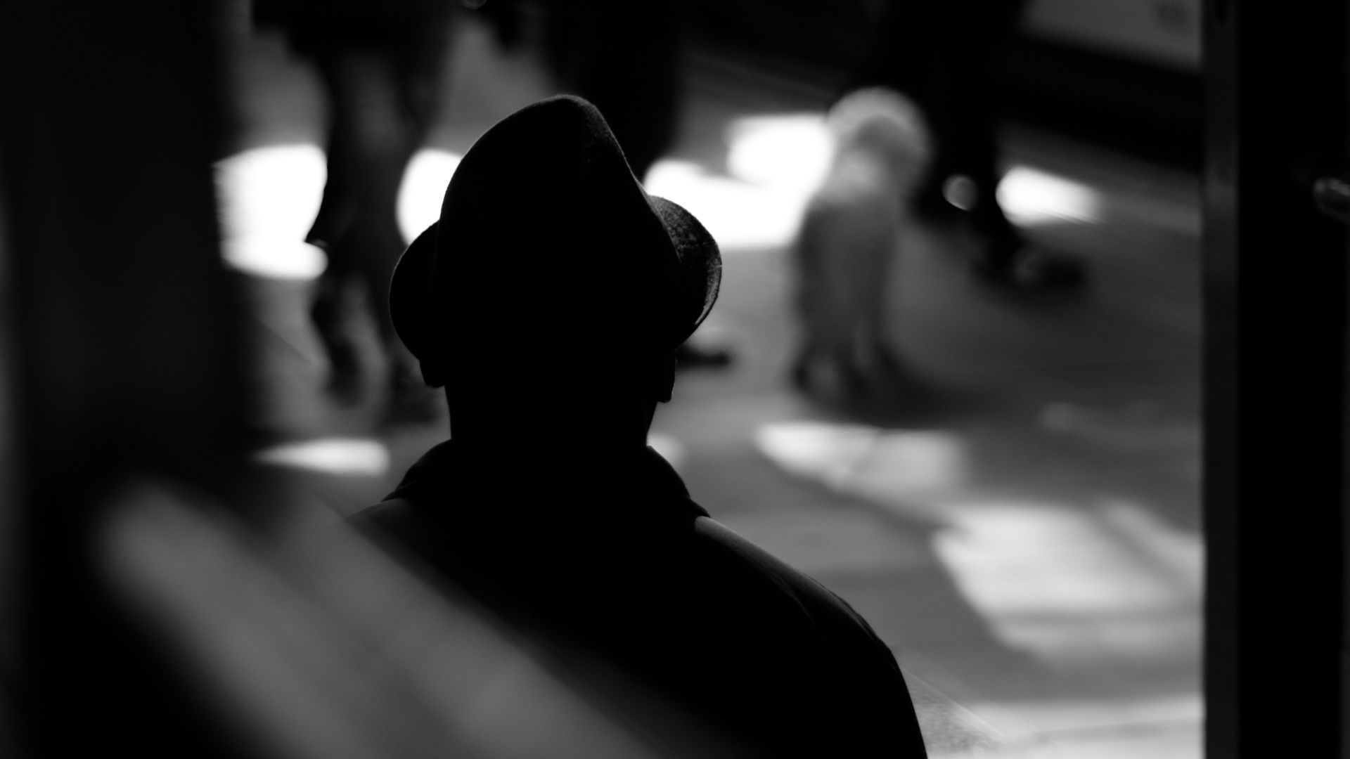 grayscale photo of person standing on train station