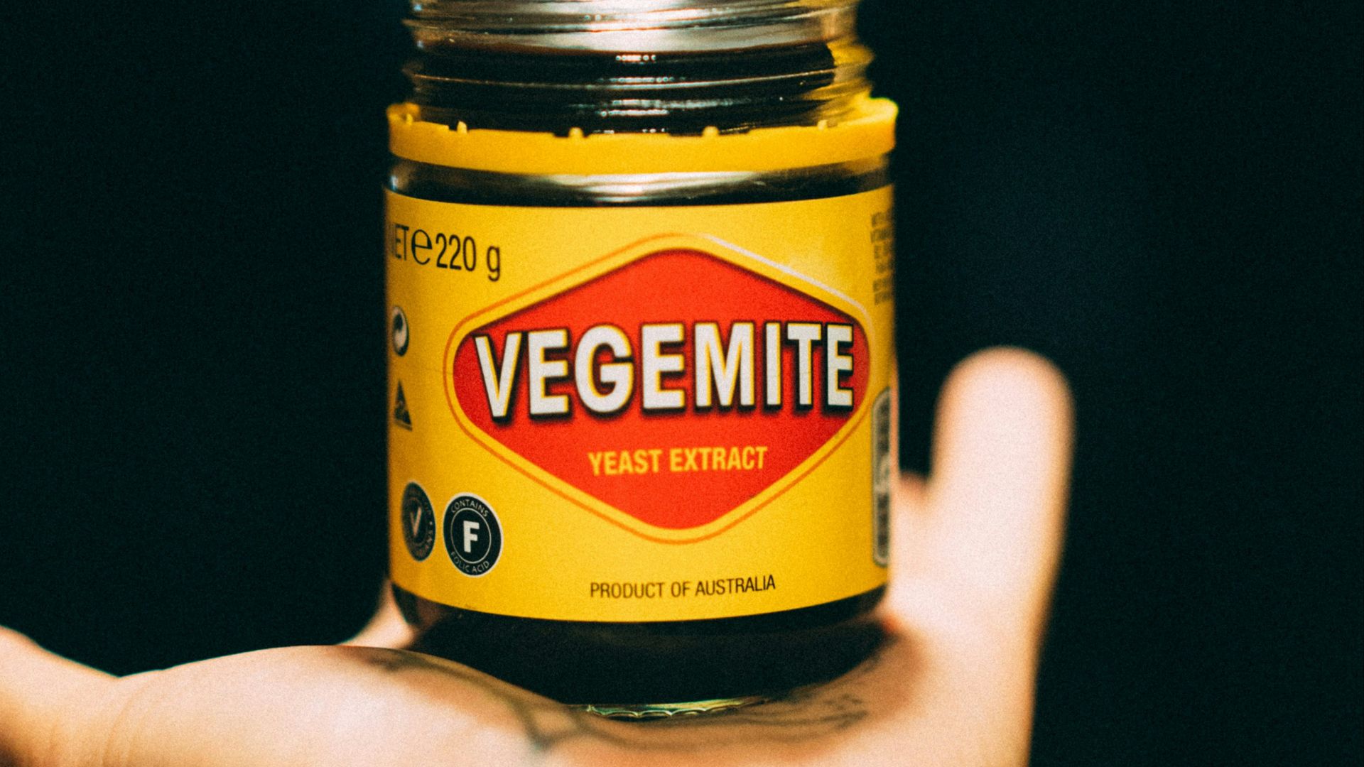 person holding yellow and black bottle