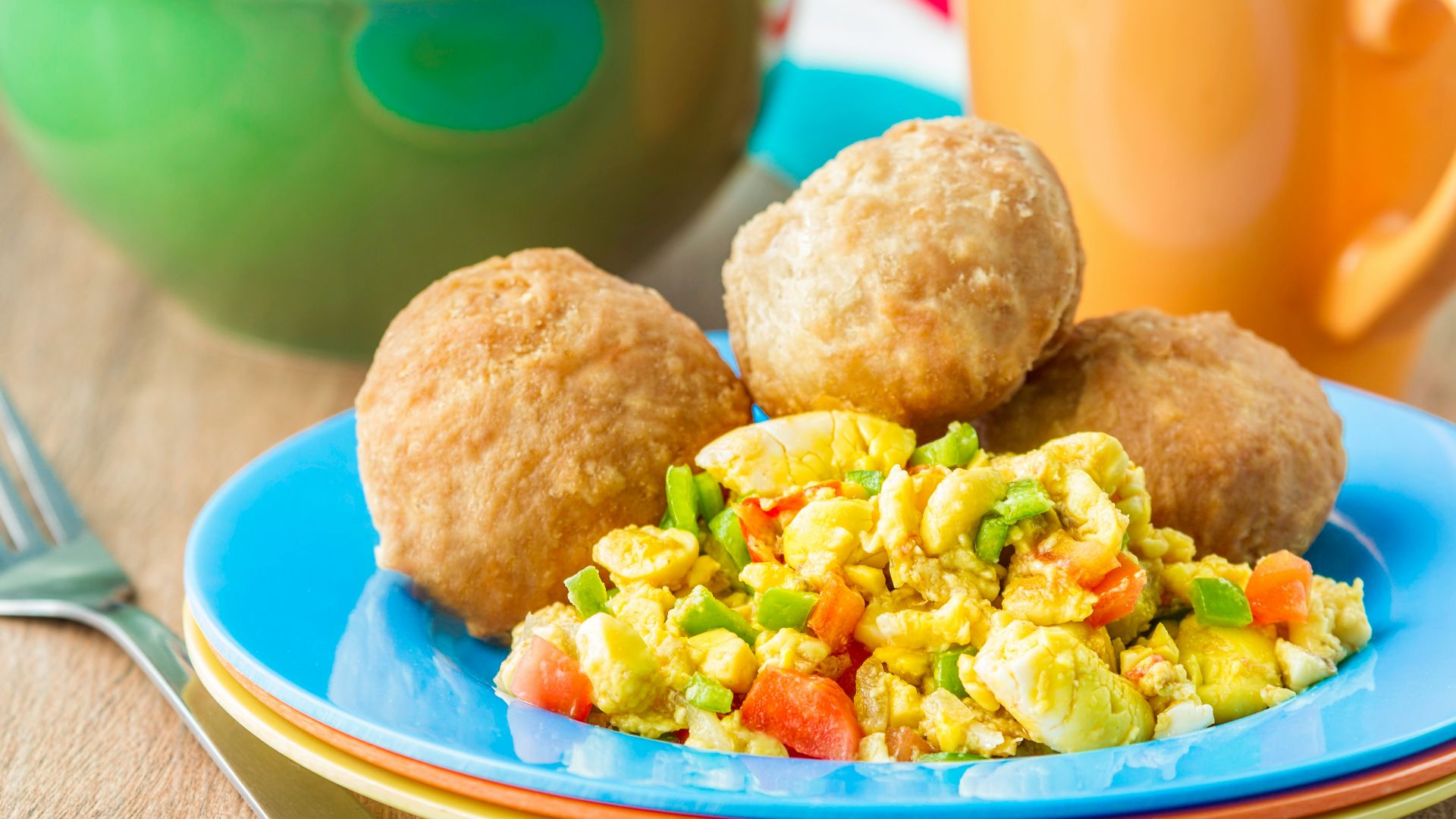 a blue plate topped with food next to a cup of coffee