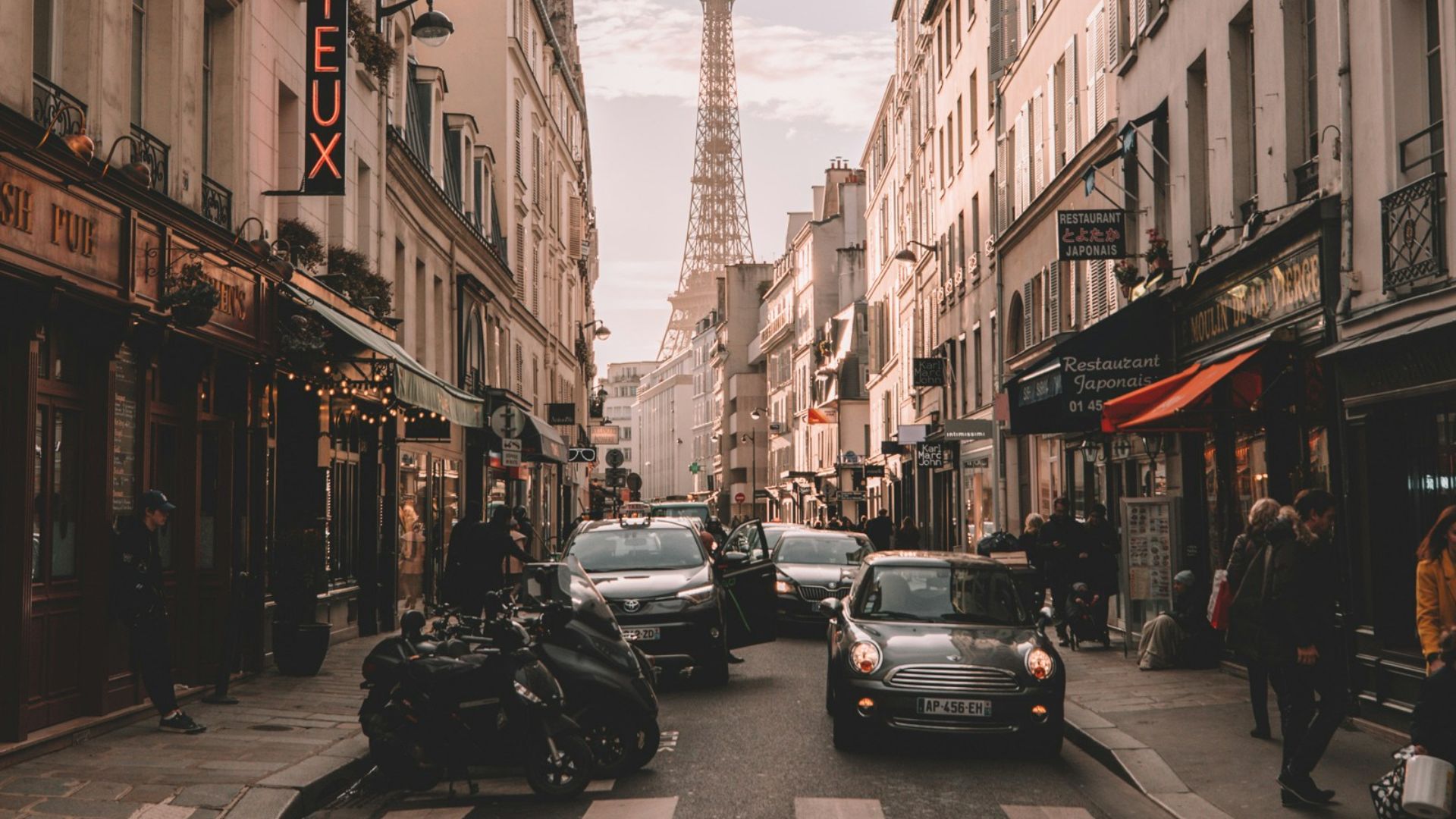 vehicles travelling on road surrounded by buildings during daytime