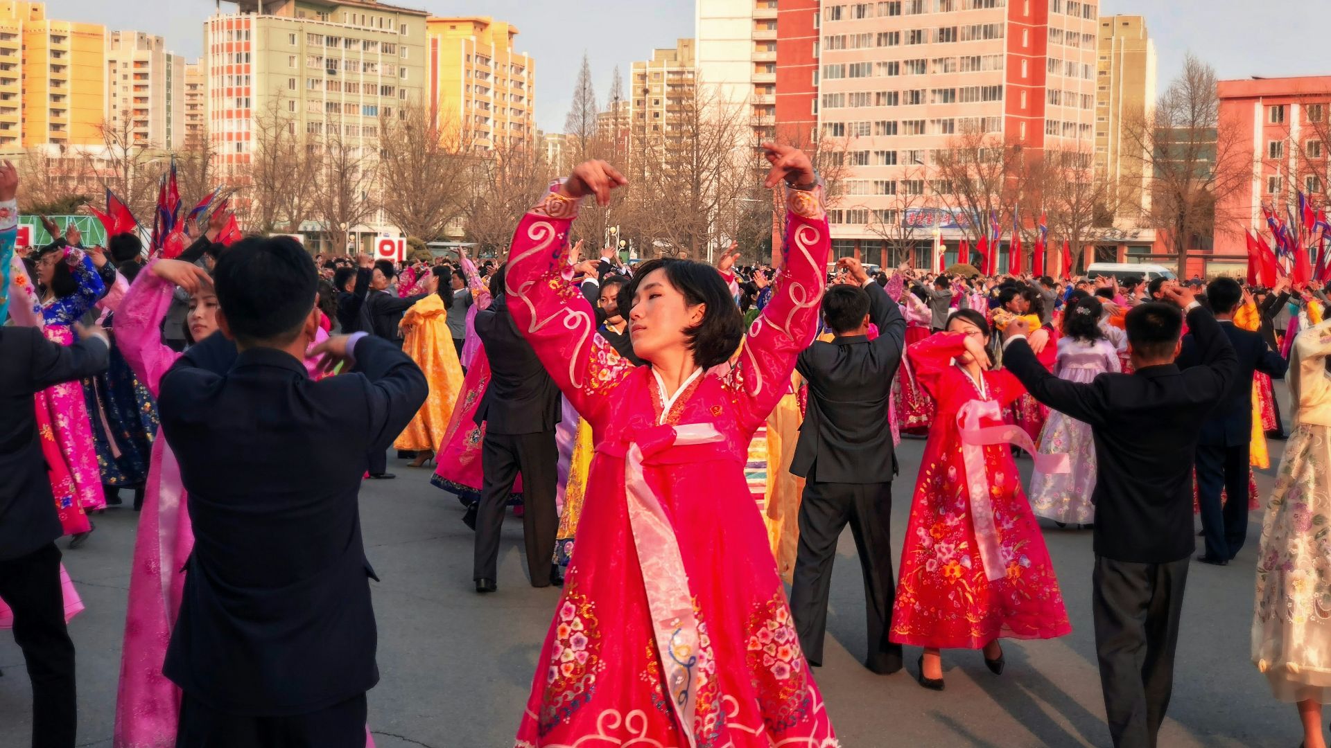 people in red and blue dress dancing on street during daytime