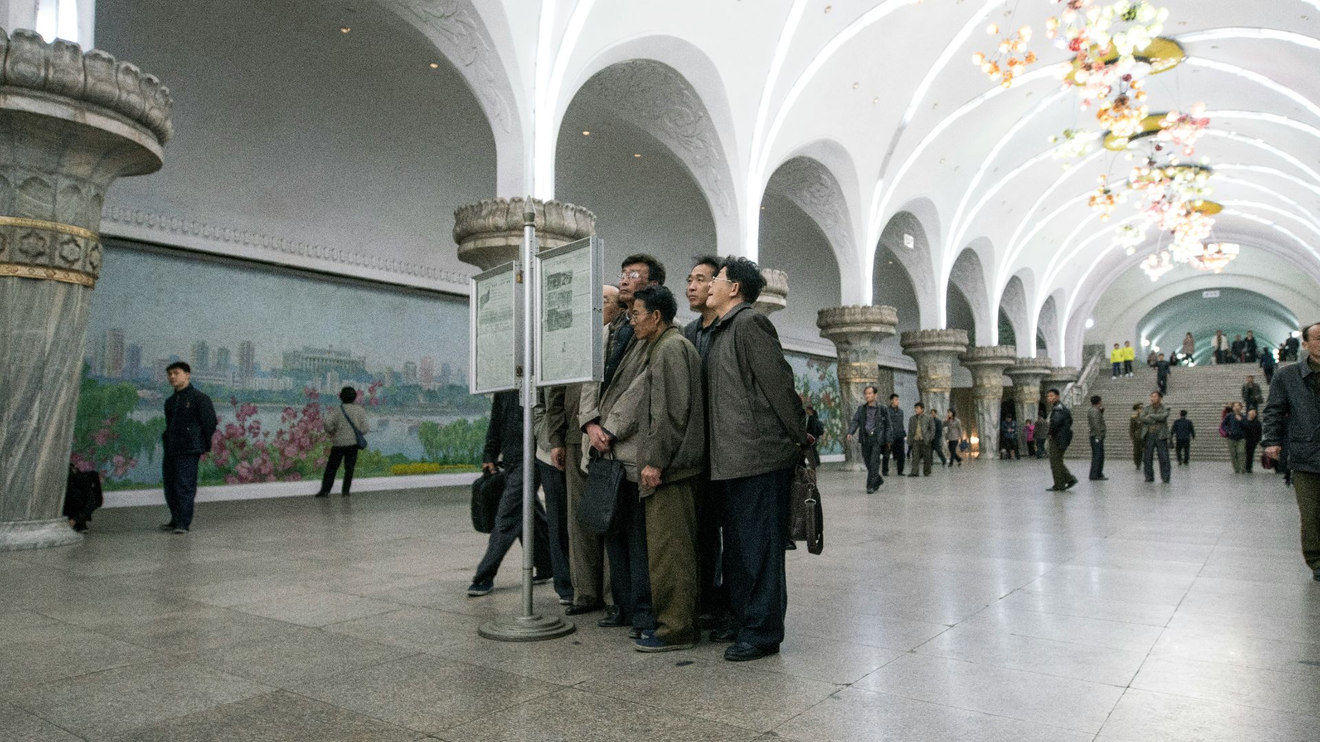 group of men standing beside signage