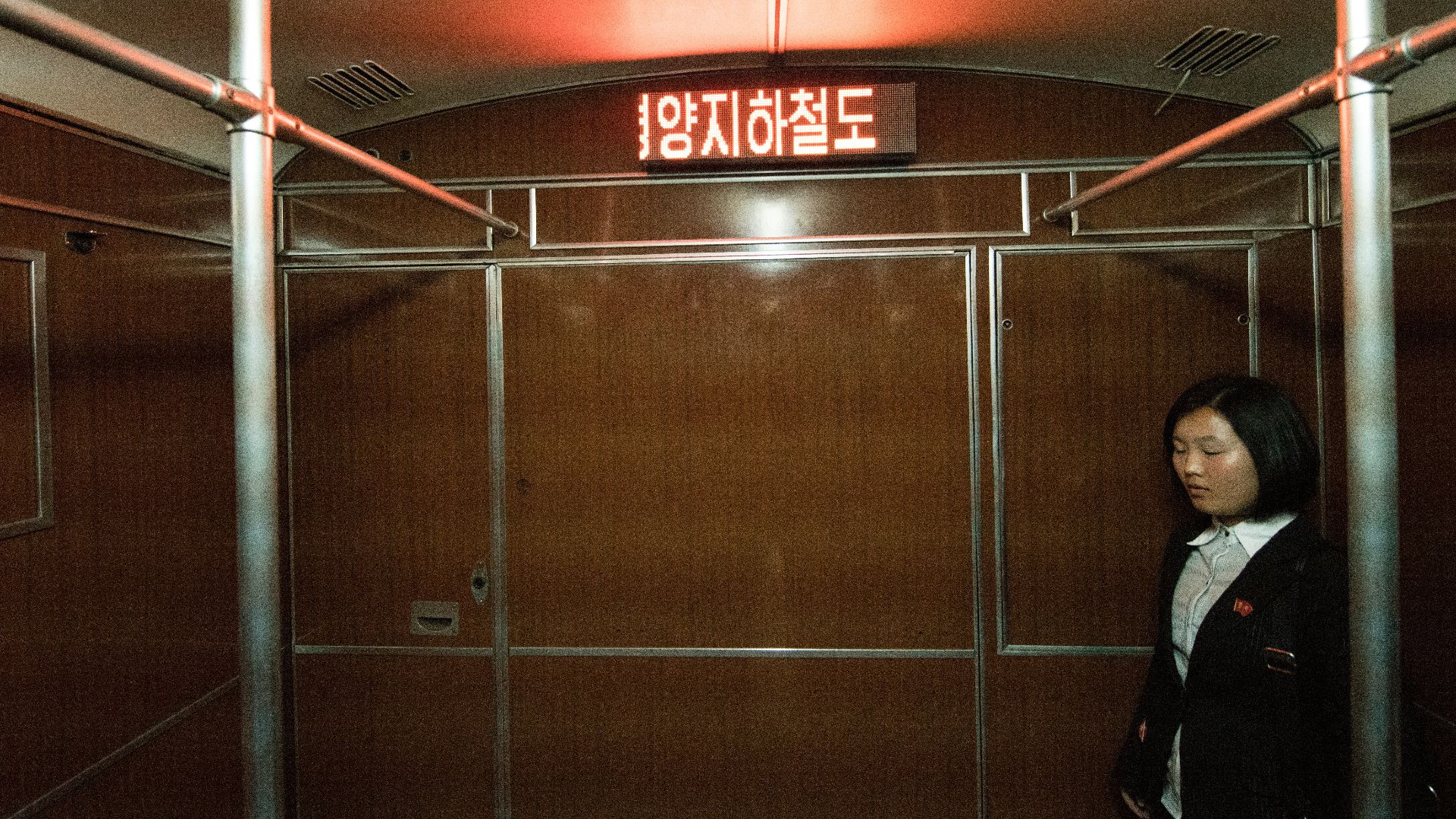 woman standing near the brown wooden wall