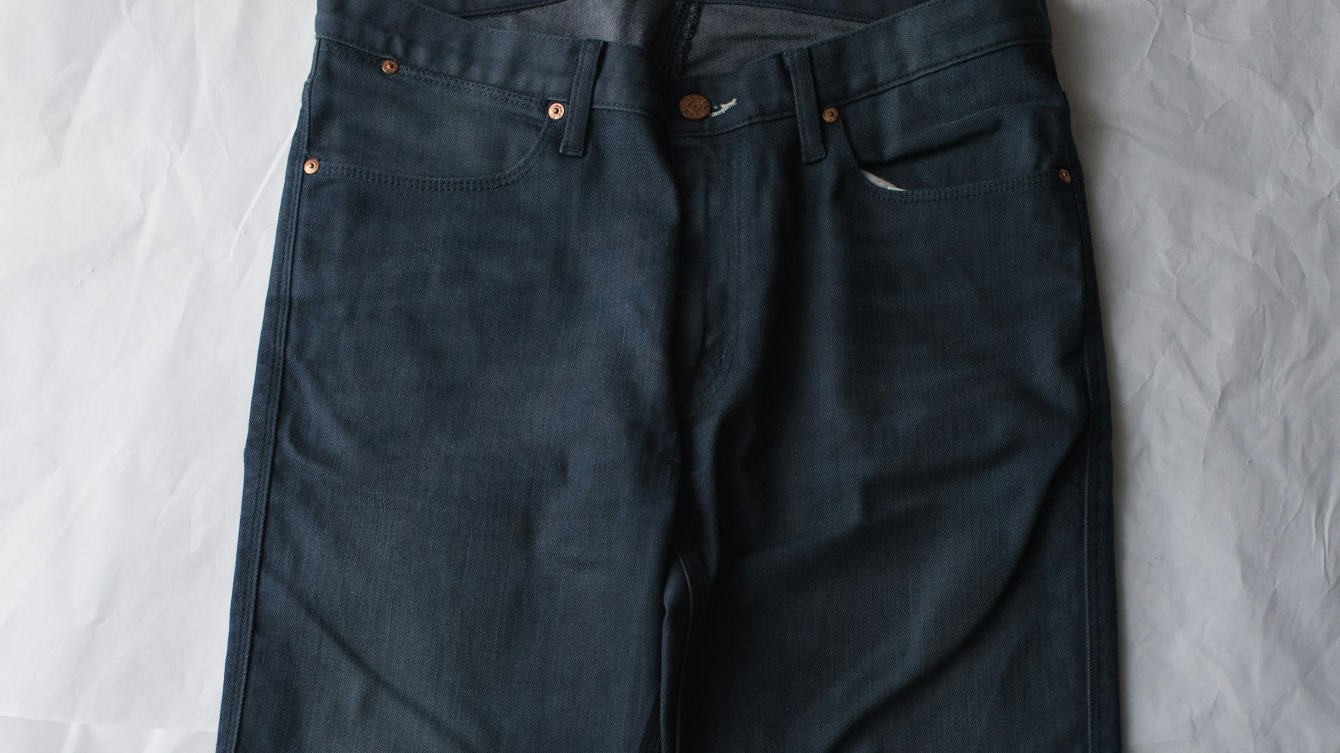 blue denim jeans on white textile