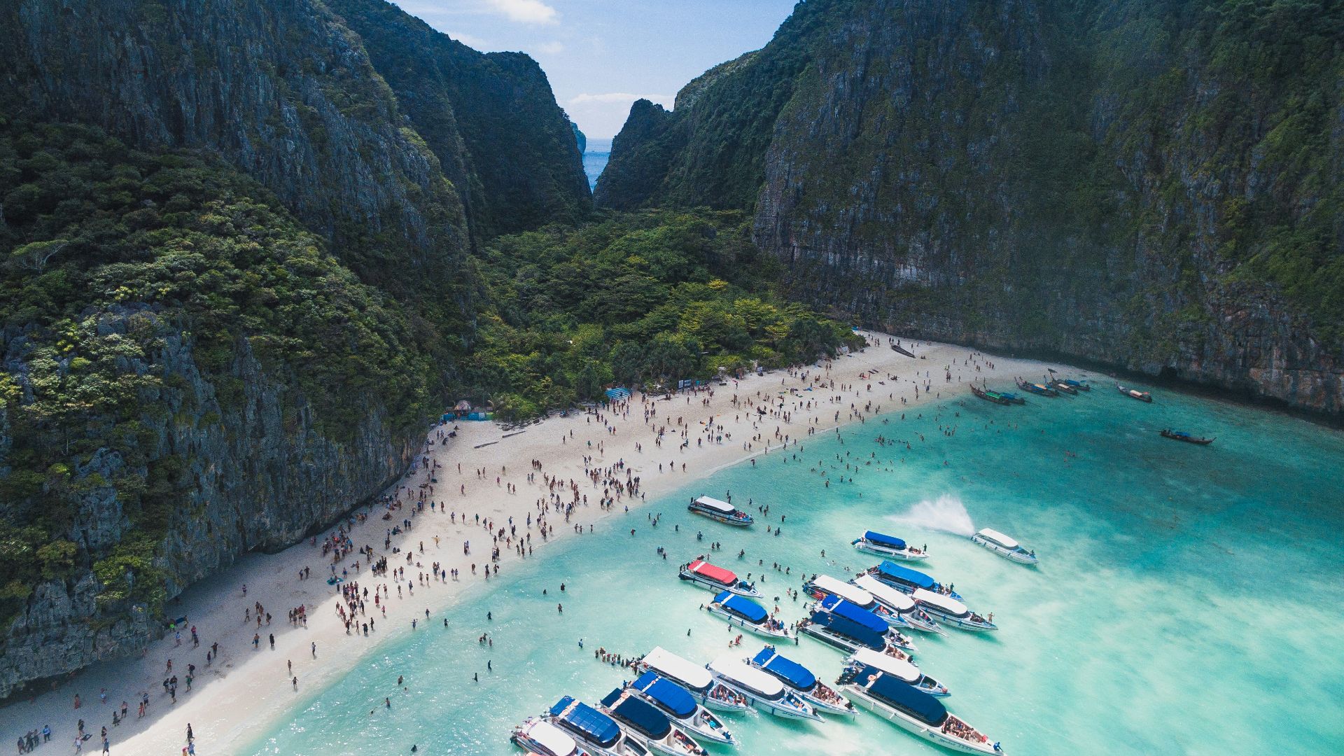 bird's eye view photography of boats in front of people gathered on seashore