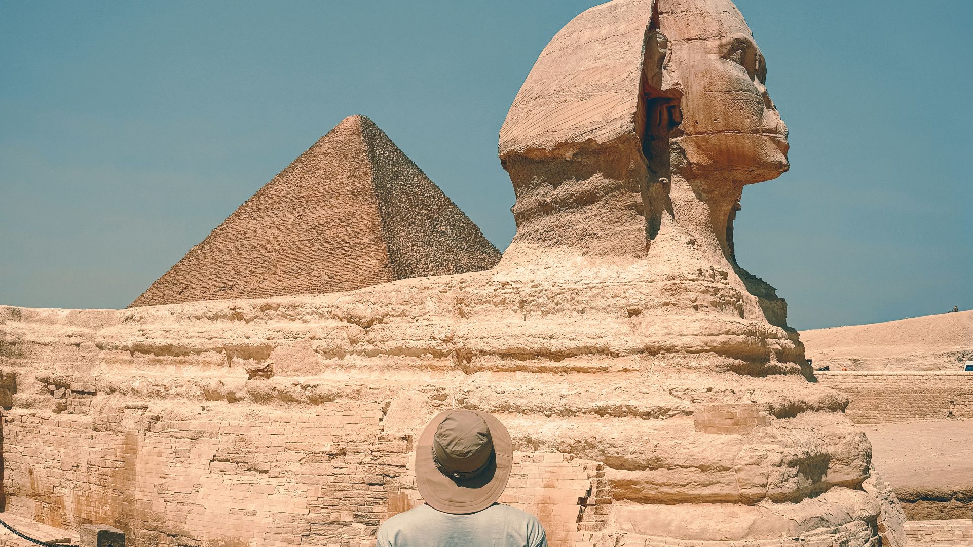 A man standing in front of a large sphinx