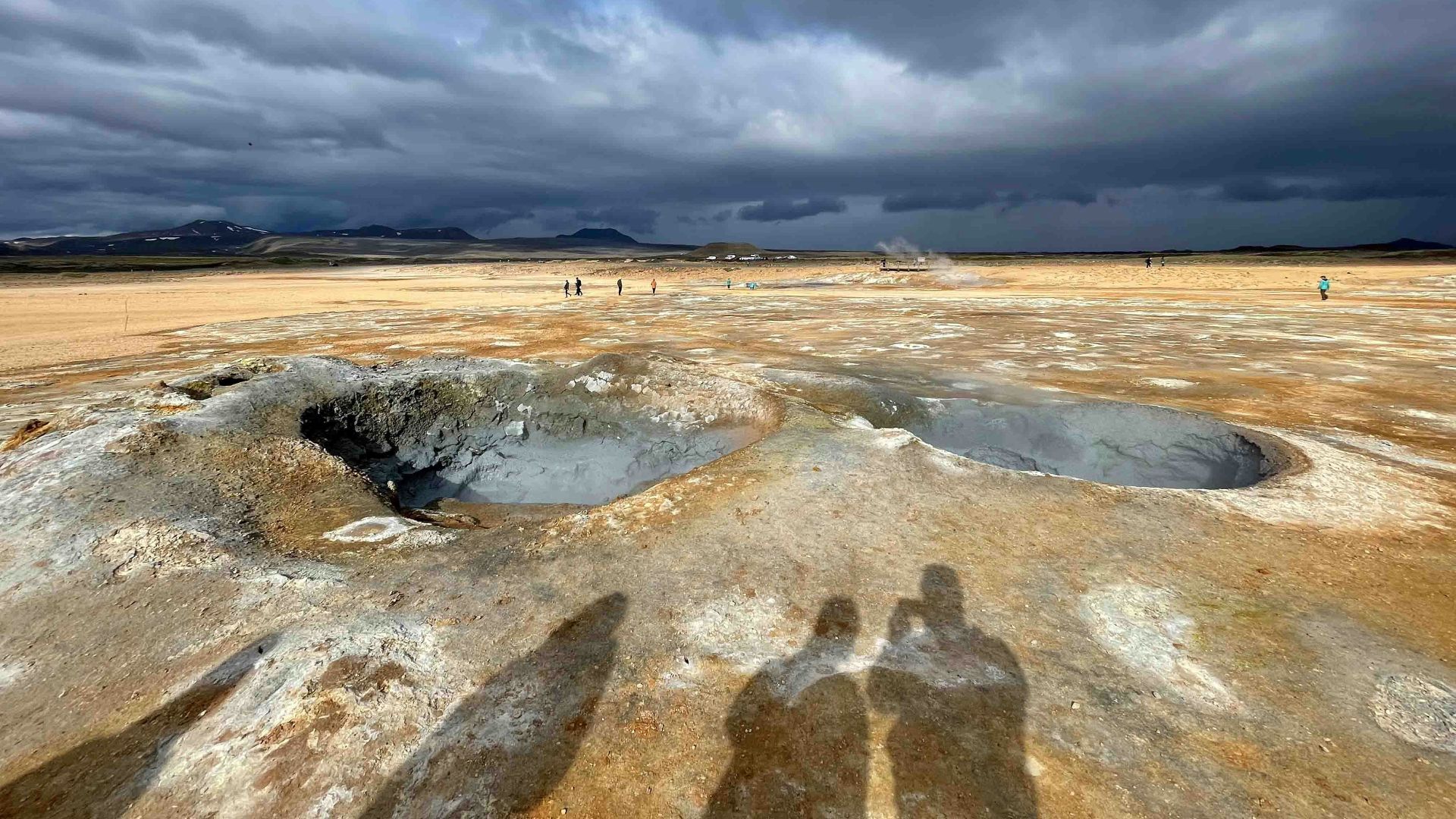 a couple of people standing on top of a dry grass field