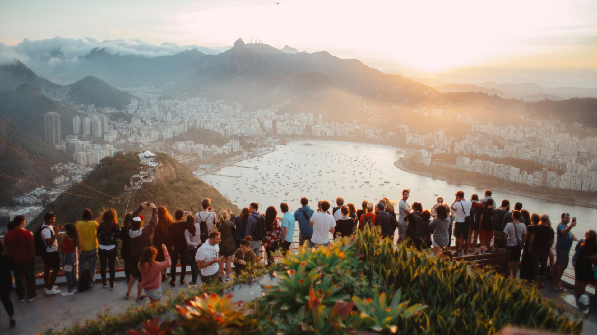 group of people standing facing lake view