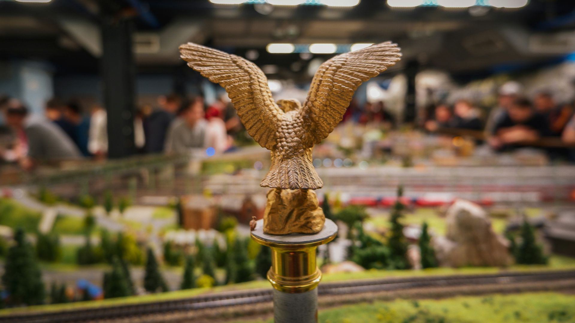 gold-colored eagle figurine on post near people