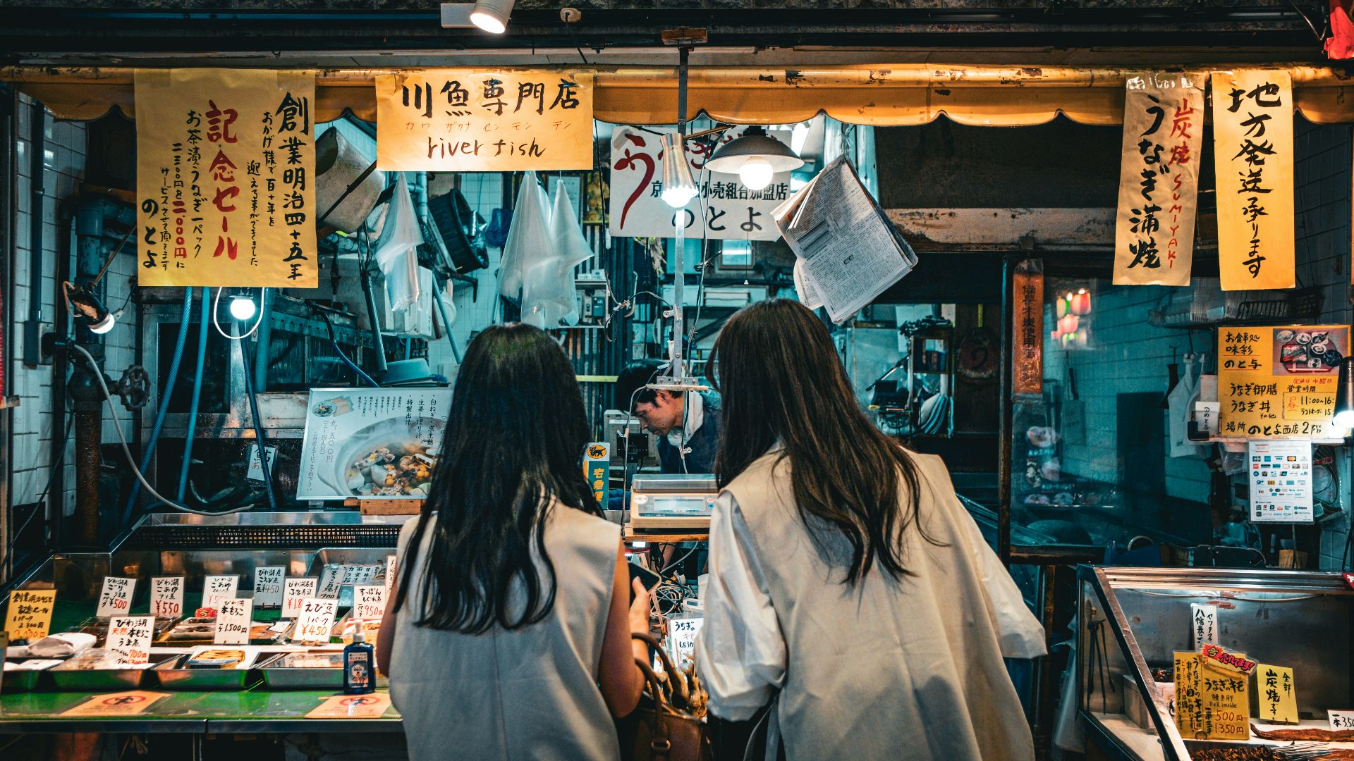 a couple of women standing next to each other in front of a store