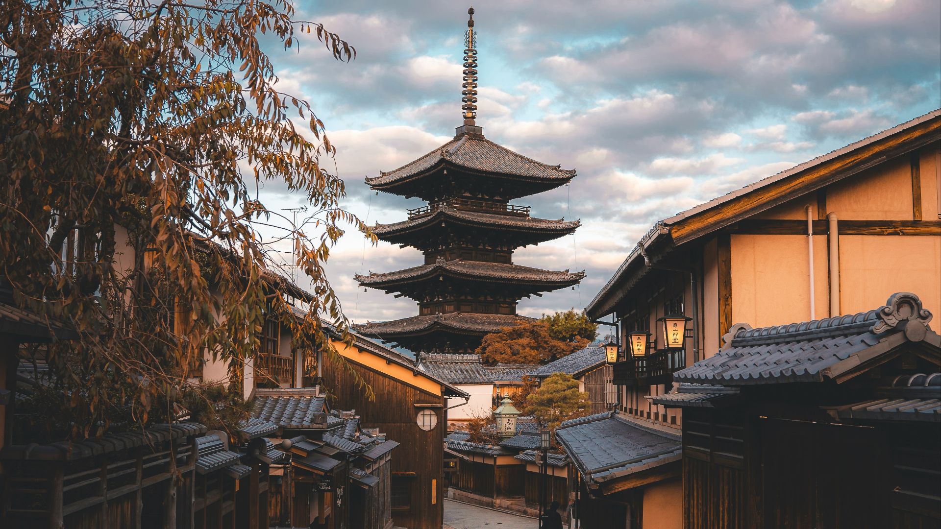 a narrow street with a pagoda in the background
