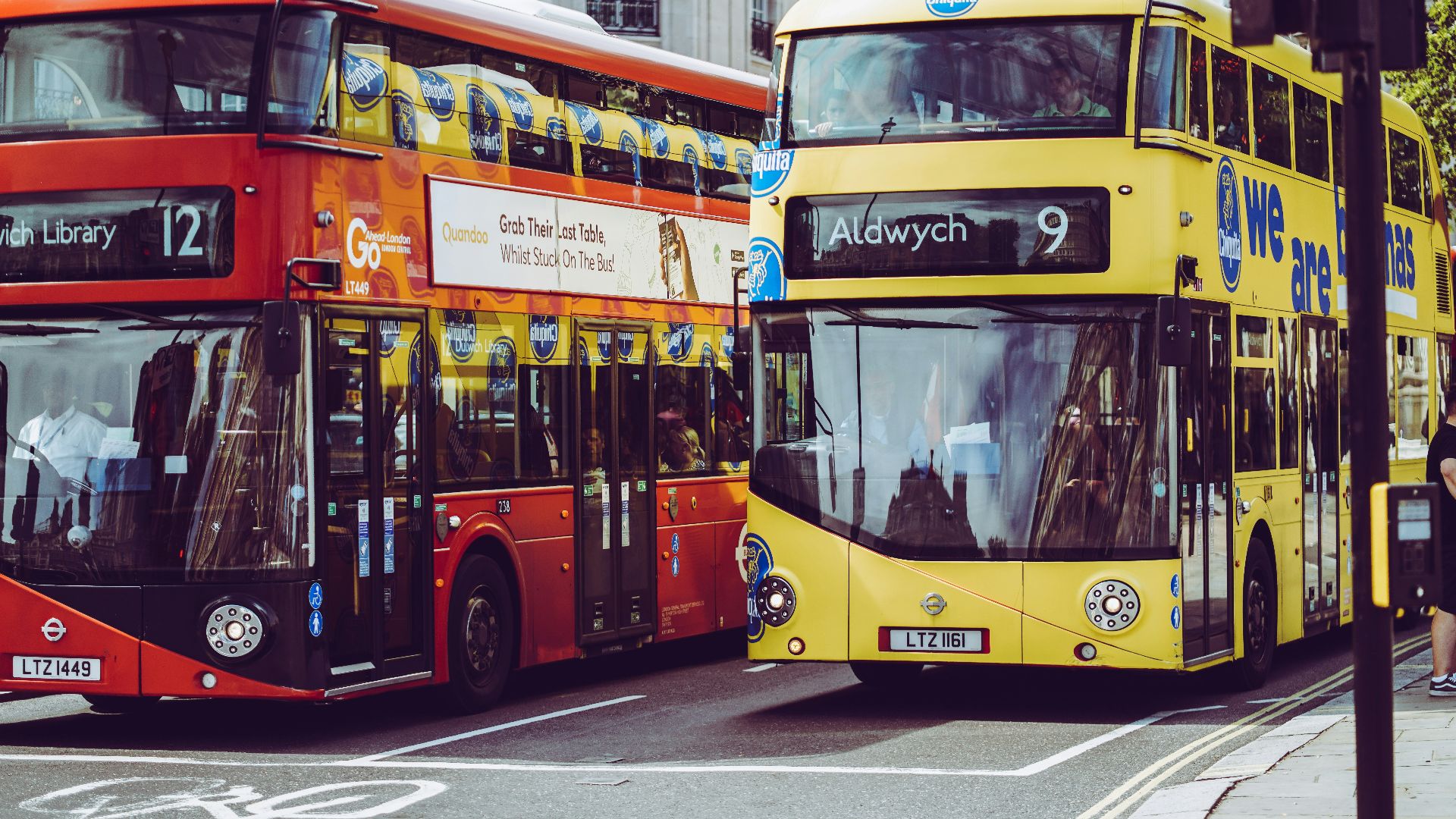 two yellow and red double-decker buses on gray concrete road